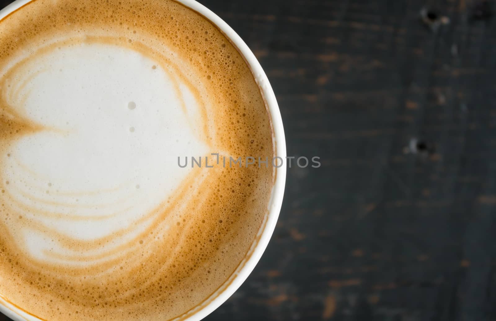 Flatlay Half Heart Shape Froth Milk Latte Art in White Coffee Cup on Black Wood Table. Heart shape froth milk Latte art hot beverage for coffee lover