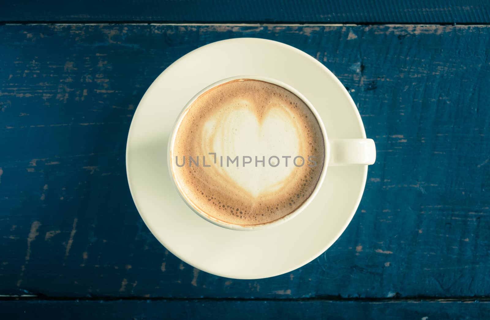 Vintage Heart Shape Froth Milk Latte Art in White Coffee Cup on Black Wood Table. Heart shape froth milk Latte art hot beverage for coffee lover