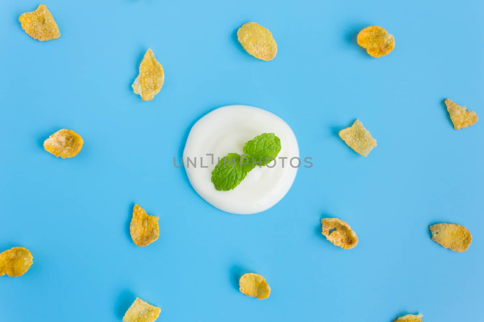 Peppermint on Yogurt with Cornflakes on Blue Pastel Background M by steafpong