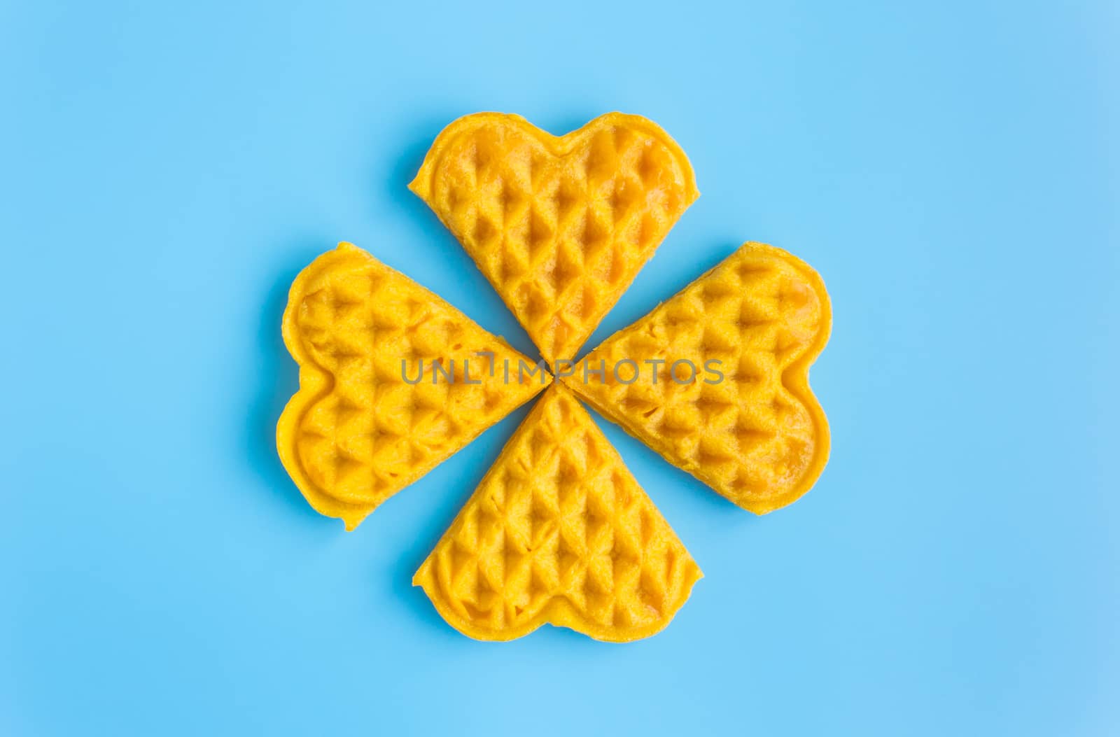 4 Pieces Waffle on Blue Pastel Background Minimalist Style. Heart shape waffle dessert in minimalist style for food and dessert category