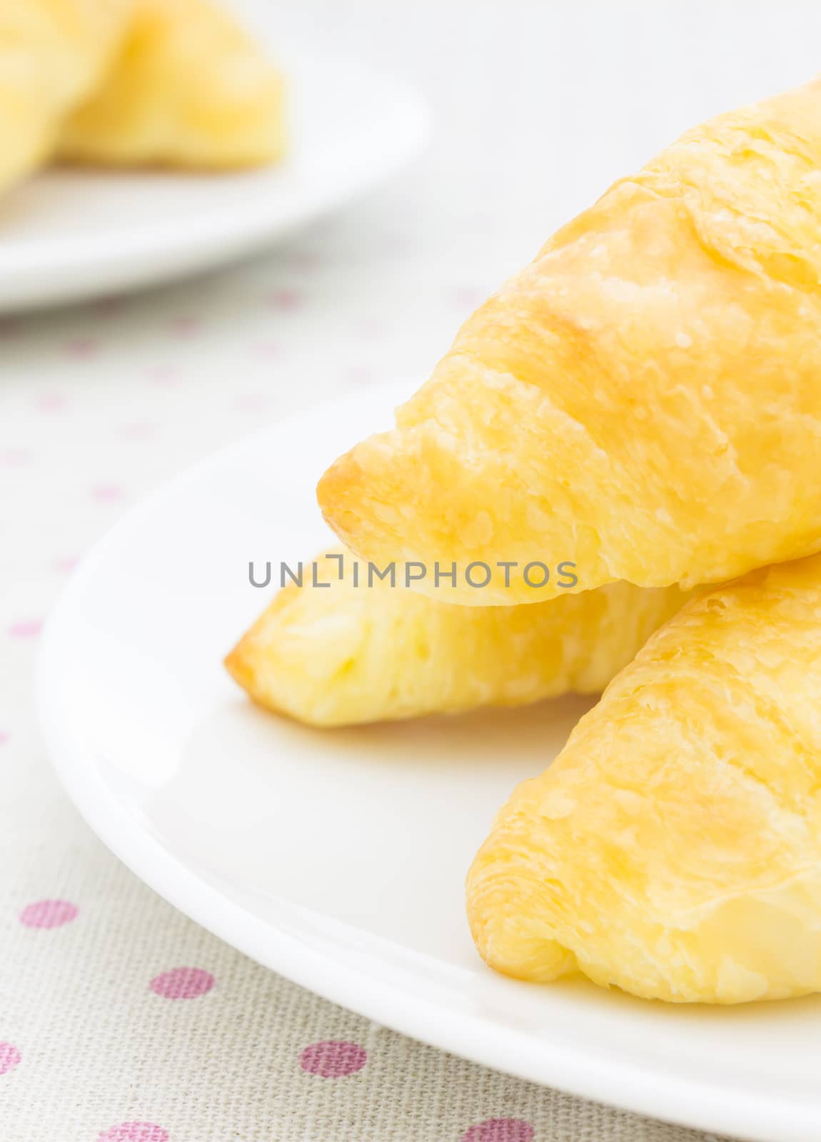 Croissant or Bread on White Dish on placemat Close up Portrait V by steafpong