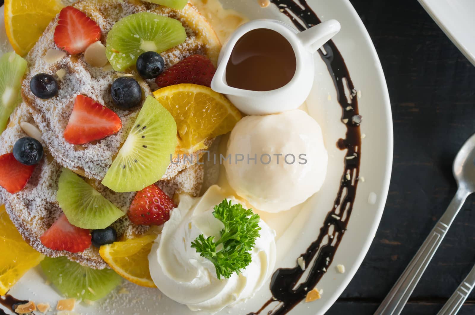 Flatlay Half Strawberry Blueberry Kiwi Lemon Waffle Whipped Cream Ice Cream Chocolate Dessert and Syrup. Fruity dessert food and drink category