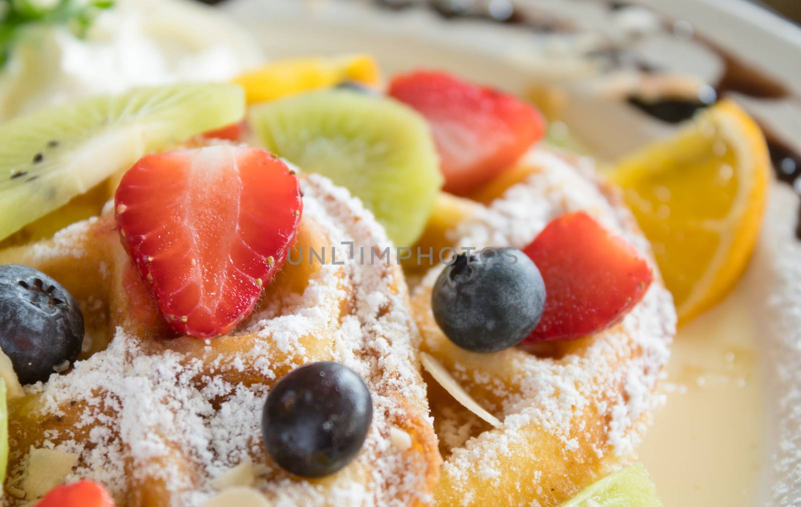 Strawberry Blueberry Kiwi Lemon Waffle Dessert Close Up. Fruity dessert food and drink category