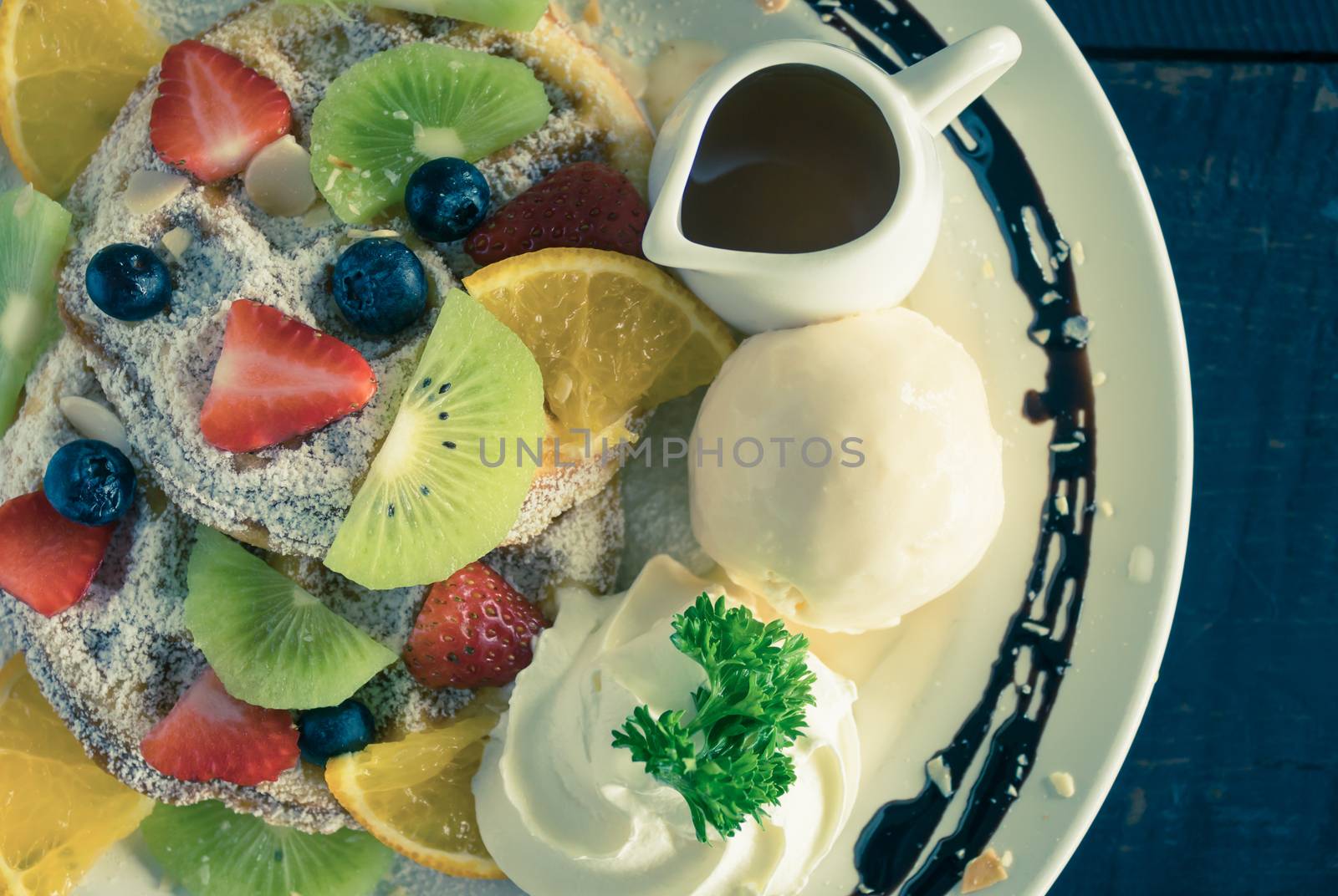 Vintage Flatlay Half Strawberry Blueberry Kiwi Lemon Waffle Whipped Cream Ice Cream Chocolate and Syrup Dessert. Fruity dessert food and drink category