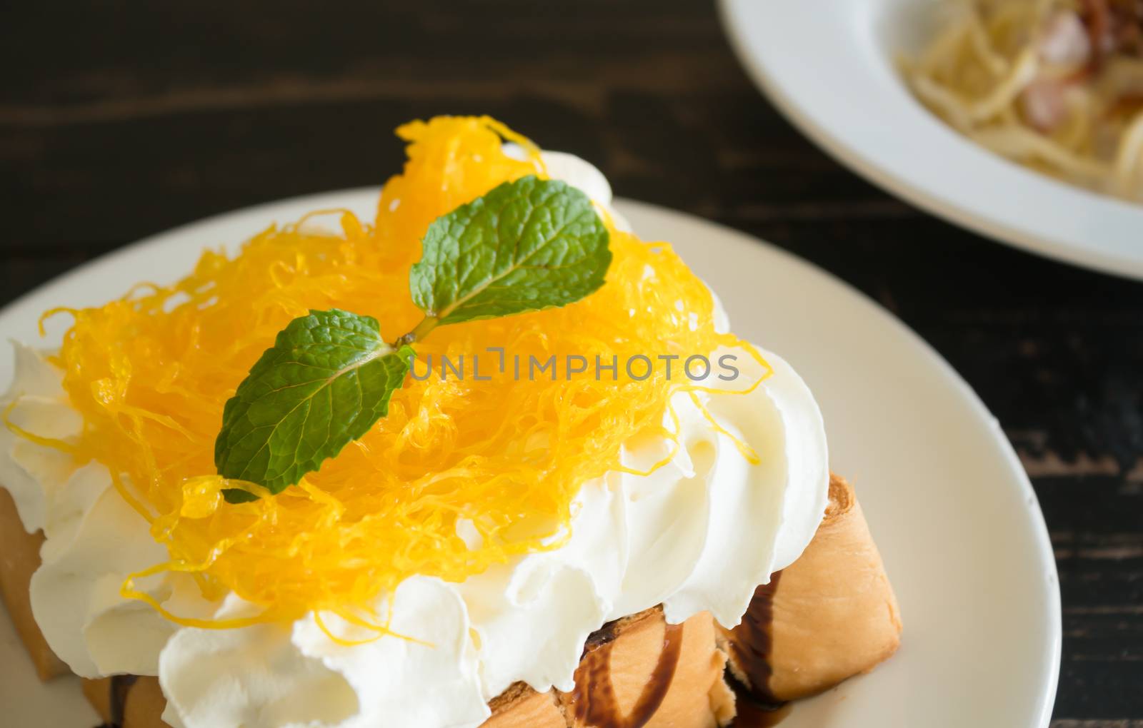 Golden Egg Yolk Threads or Foi Thong Toast and Whipped Cream and Chocolate. Thai dessert golden egg yolk threads or foi thong with peppermint on whipped cream on bread 
with chocolate sauce for food and drink category