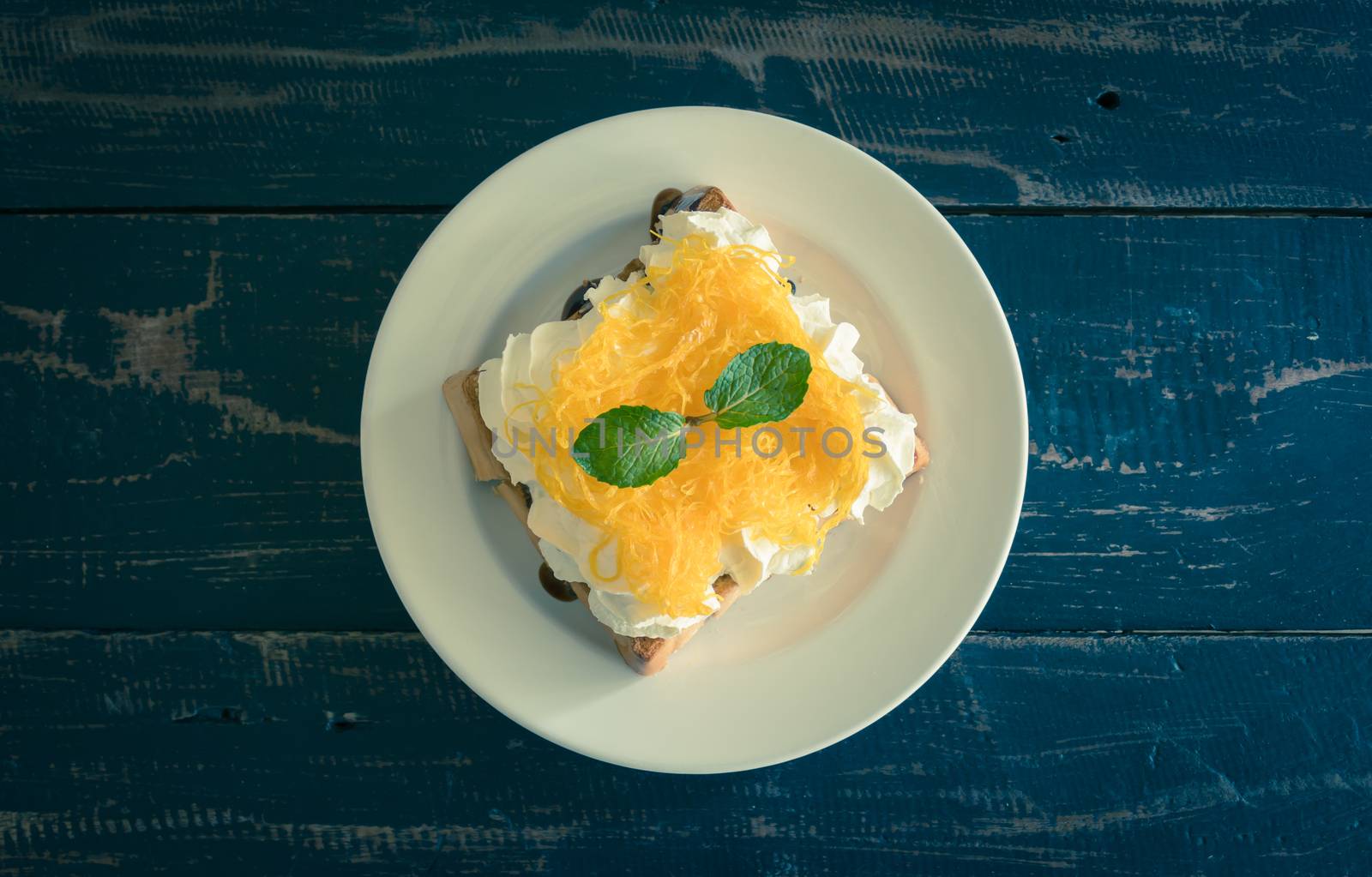 Golden Egg Yolk Threads or Foi Thong Toast and Whipped Cream and Chocolate. Thai dessert golden egg yolk threads or foi thong with peppermint on whipped cream on bread 
with chocolate sauce for food and drink category