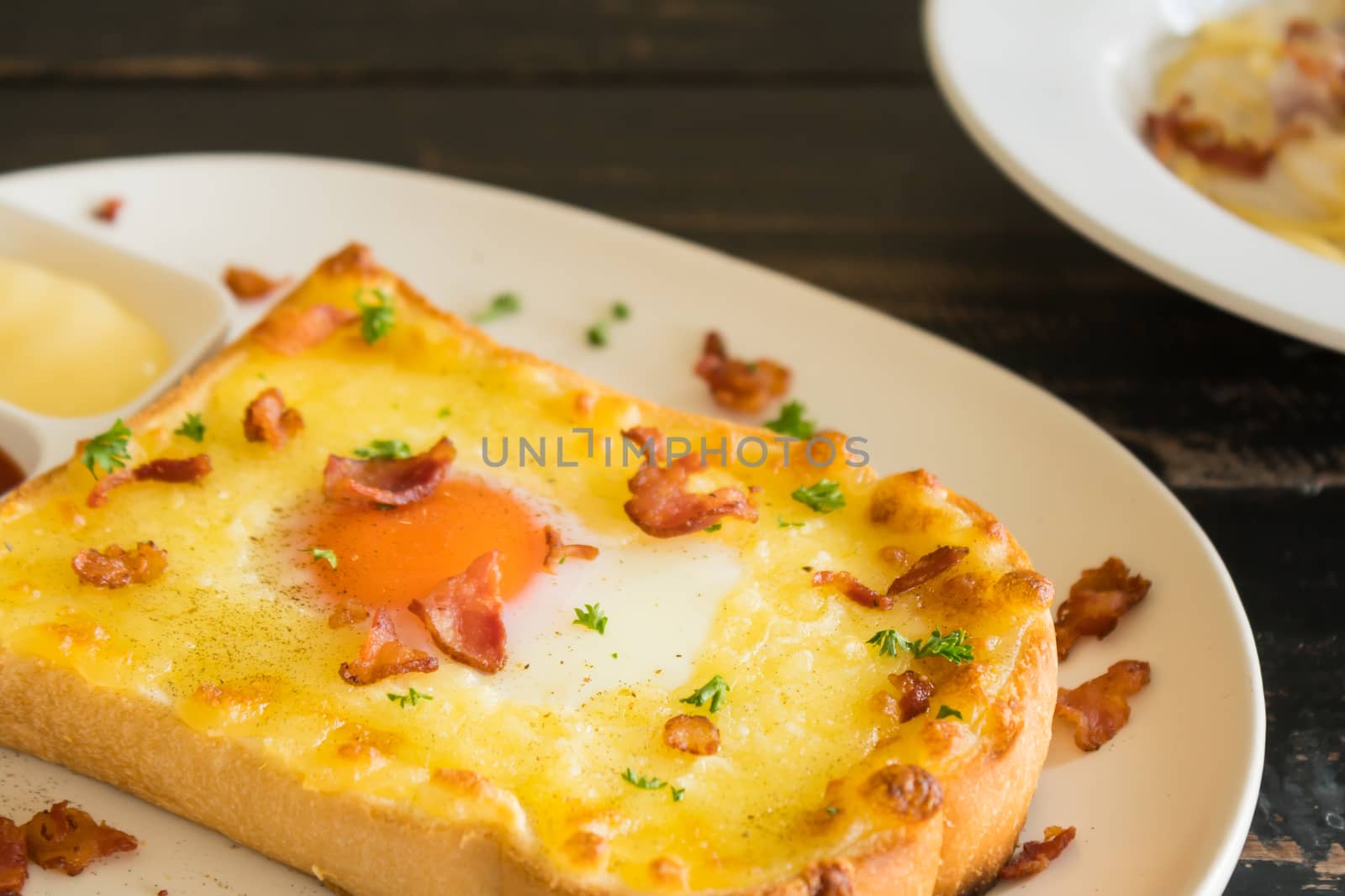 Egg Yolk Bacon Ham Cheese Toast and Coriander. Breakfast egg yolk bacon ham cheese with bread toast with coriander on top for food and drink category