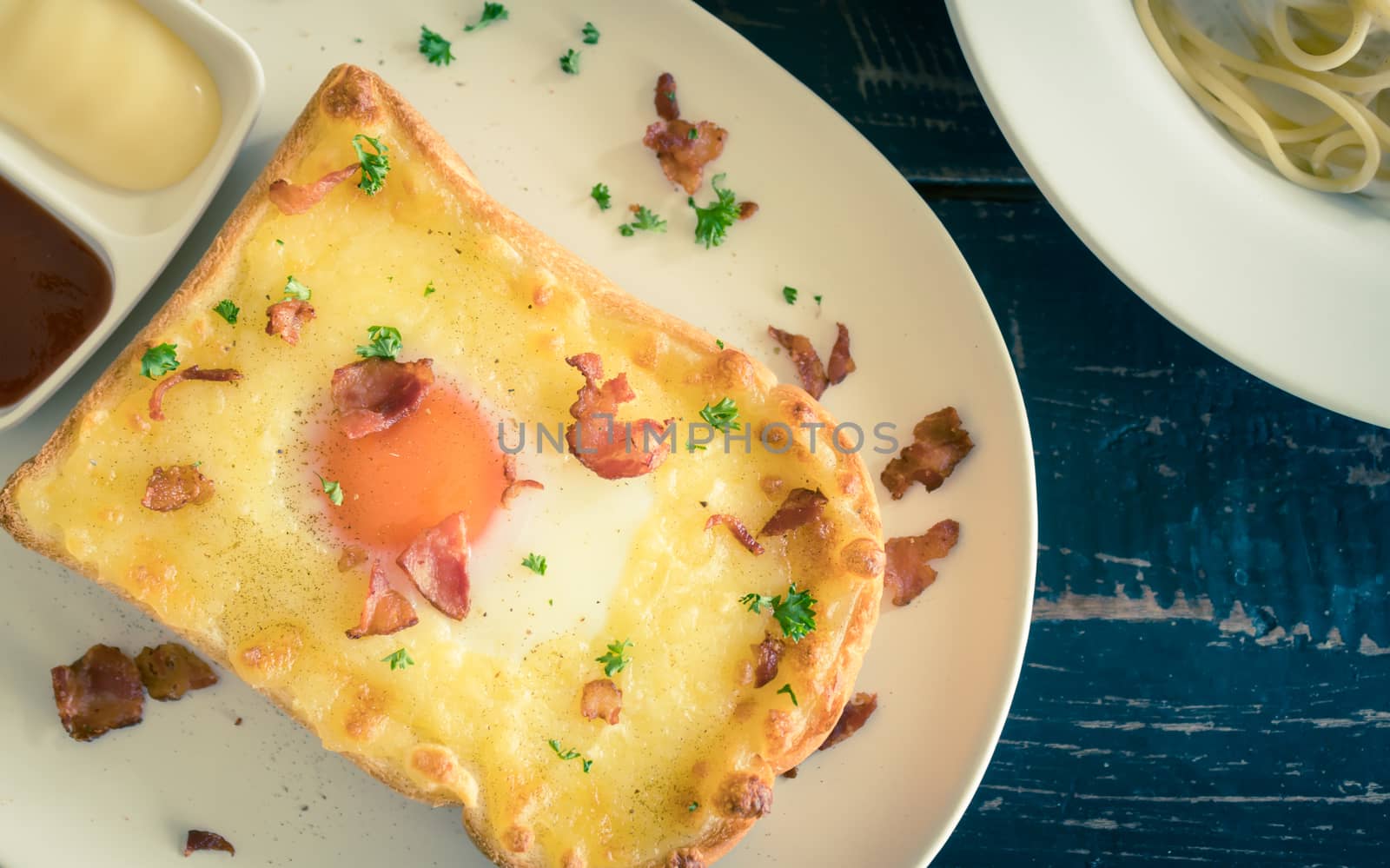 Egg Yolk Bacon Ham Cheese Toast and Coriander. Breakfast egg yolk bacon ham cheese with bread toast with coriander on top for food and drink category