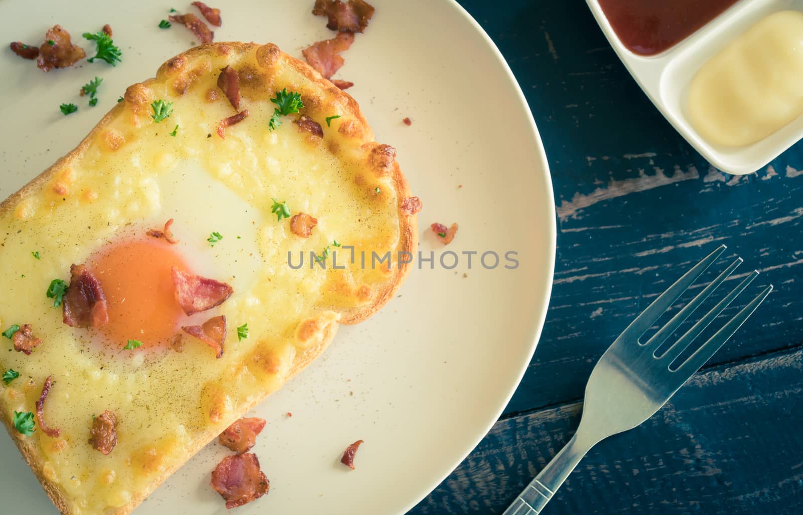 Egg Yolk Bacon Ham Cheese Toast and Coriander. Breakfast egg yolk bacon ham cheese with bread toast with coriander on top for food and drink category