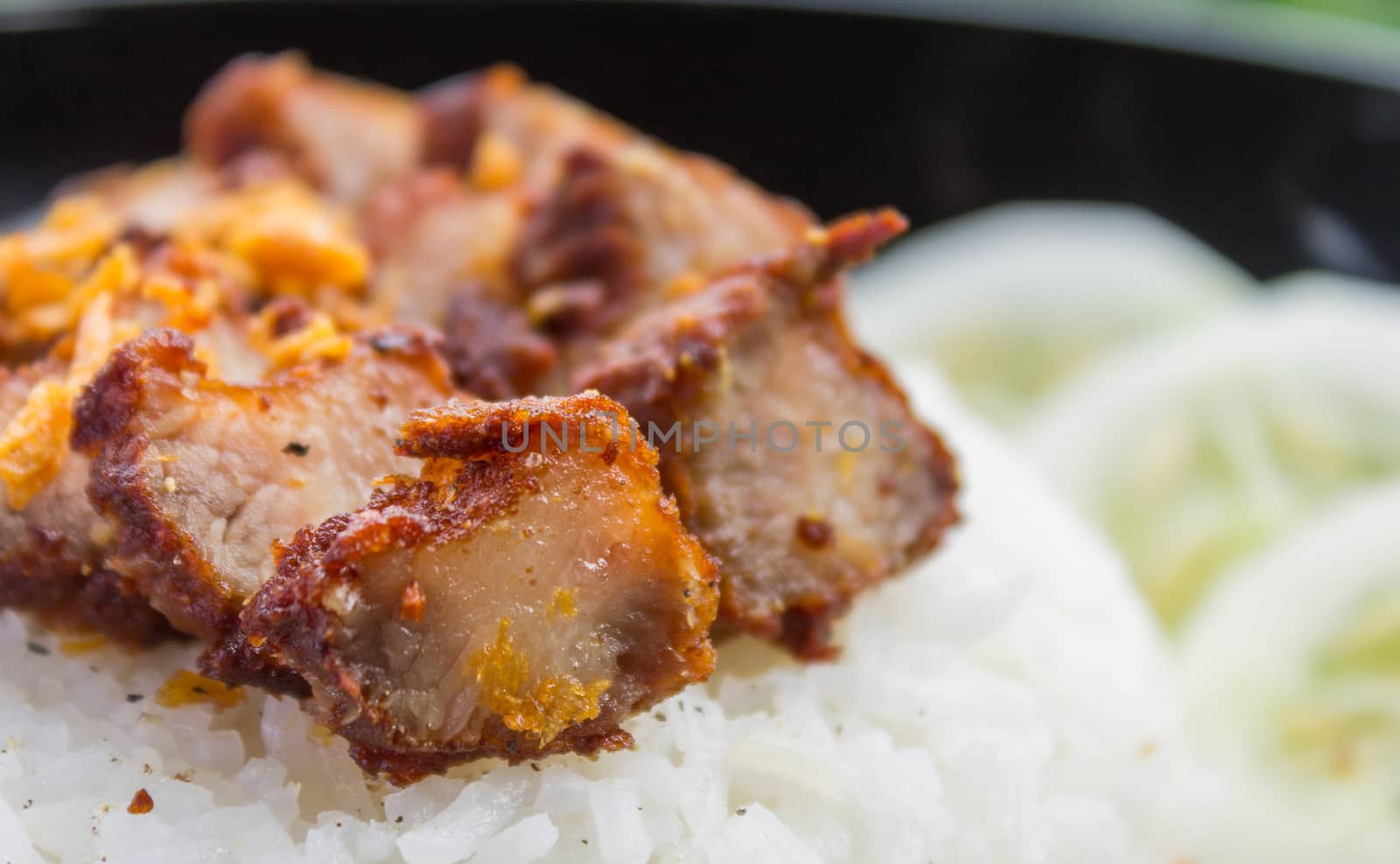 Thai Food Fried Pork with Garlic and Cucumber in Black Dish. Fried pork with garlic or steak on rice and cucumber in food and drink category