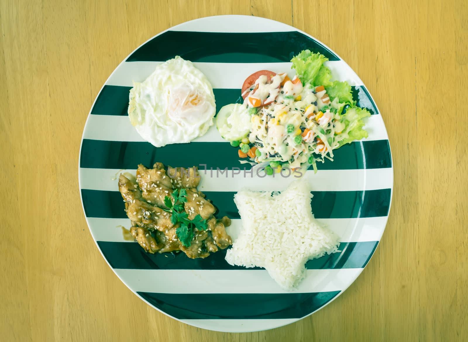 Fried Chicken with Garlic and Pepper and Fried Egg and Vegan Salad and Rice in Dish on Wood Table with Natural Light on Flatlay View in Vintage Tone