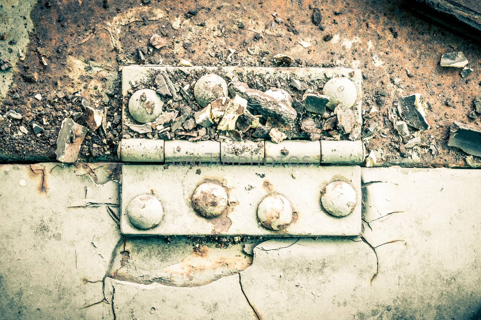 Old metal hinge and rust and rivet on old metal sheet of auto part in horizontal view high contrast style. Grunge or retro or old background for industry design.