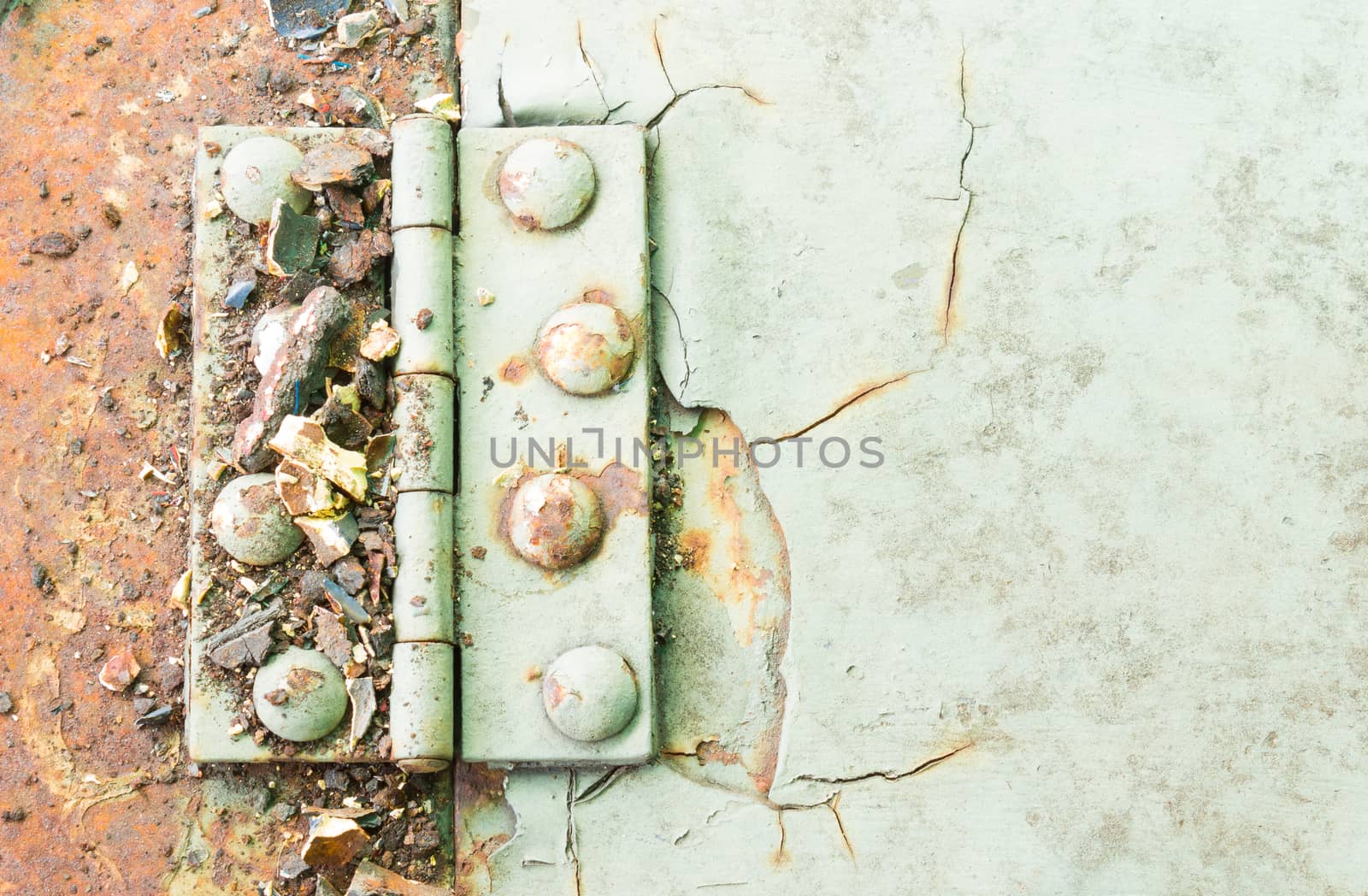 Old metal hinge and rust and rivet on old metal sheet of auto part. Grunge or retro or old background for industry design.