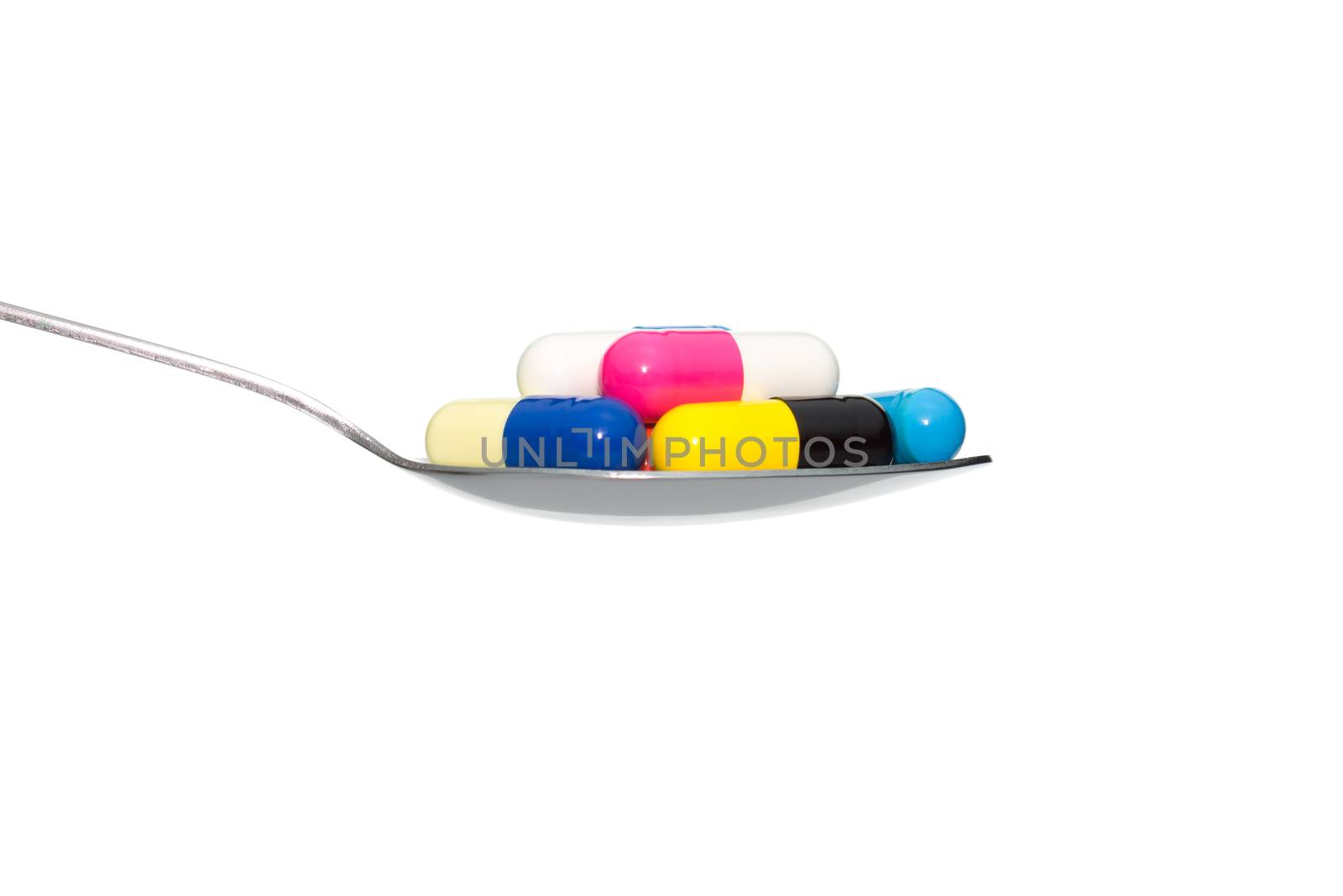 Various color drug or pill or vitamin on metal Spoon isolated on white background. Concept about health care or medical or science including food concept.