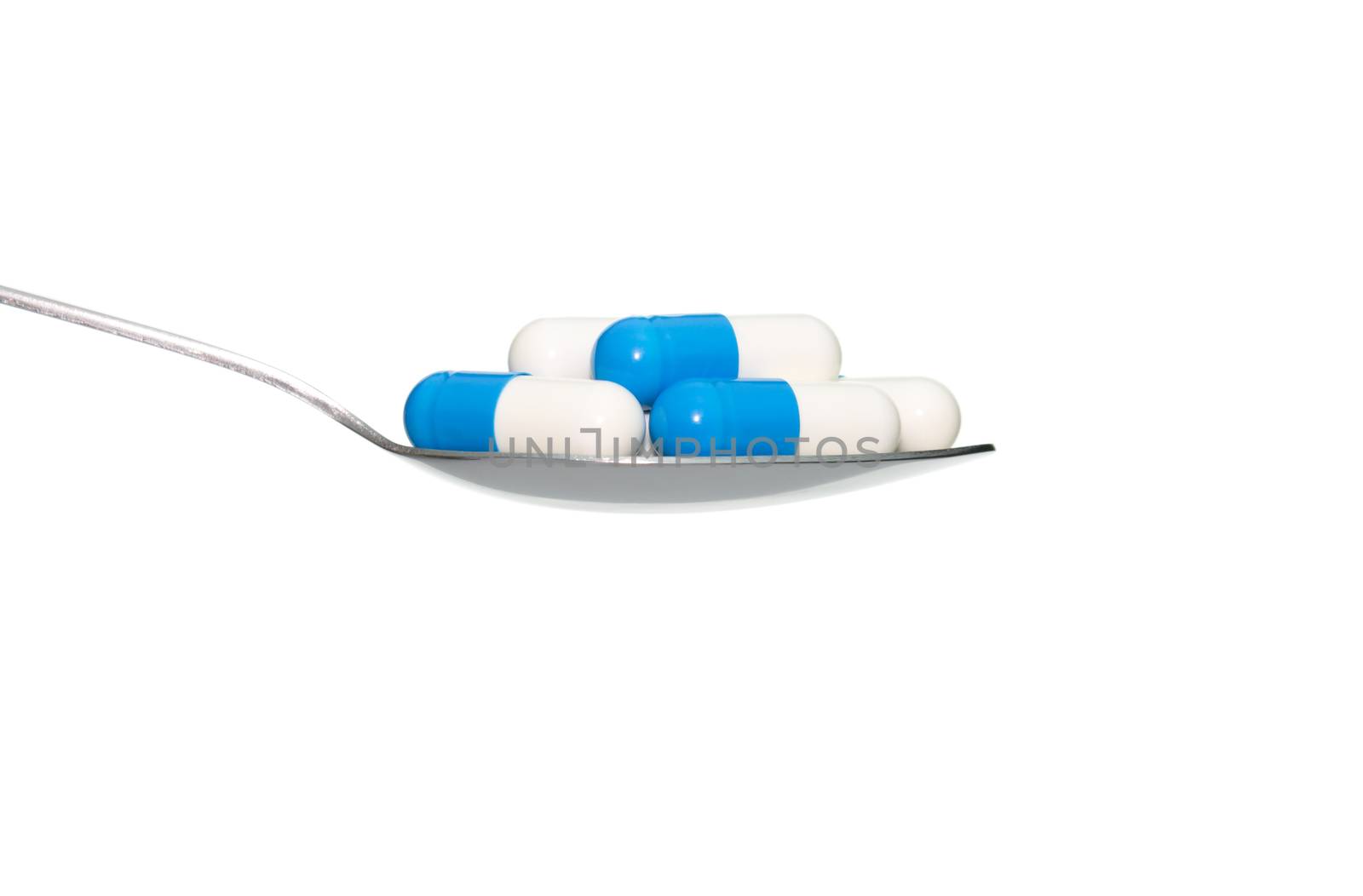 Blue white drug or pill or vitamin on metal Spoon isolated on white background. Concept about health care or medical or science including food concept.