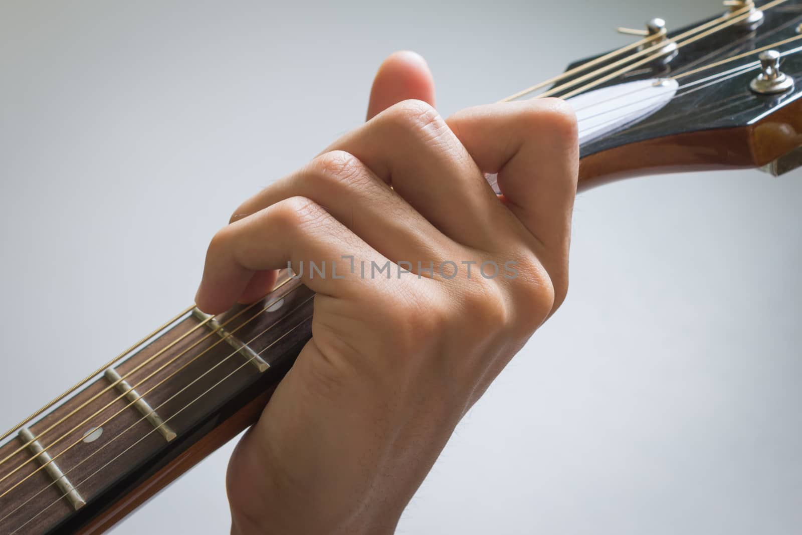Guitar Player Hand or Musician Hand in C Major Chord on Acoustic Guitar String with soft natural light in close up view