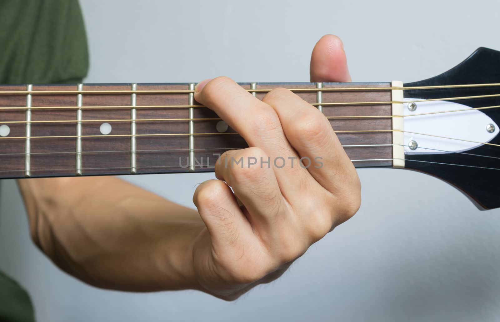 Guitar Player Hand or Musician Hand in G Major Chord on Acoustic Guitar String with soft natural light in close up view