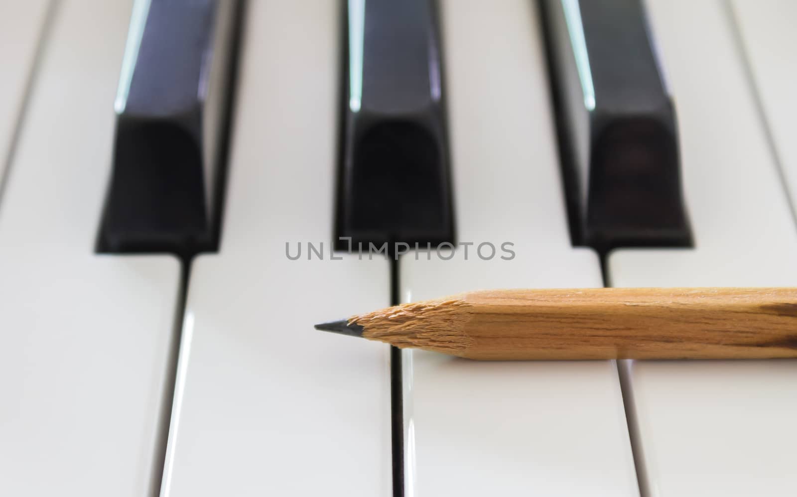 Old Pencil on White Keys of Electric Piano in Horizontal View. Concept about Piano Playing or Piano Learning