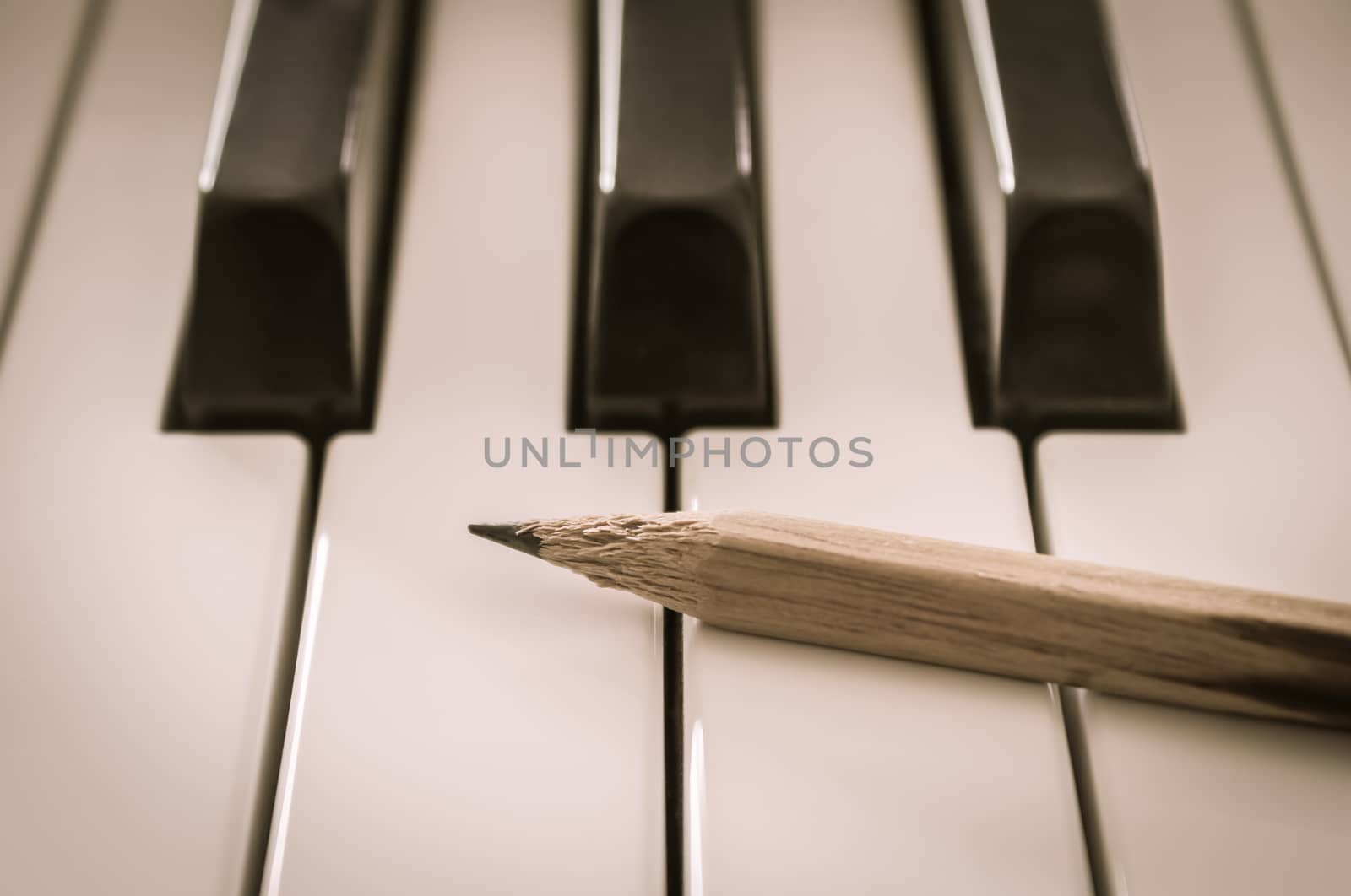 Old Pencil on White Keys of Electric Piano in Crosswise View. Concept about Piano Playing or Piano Learning