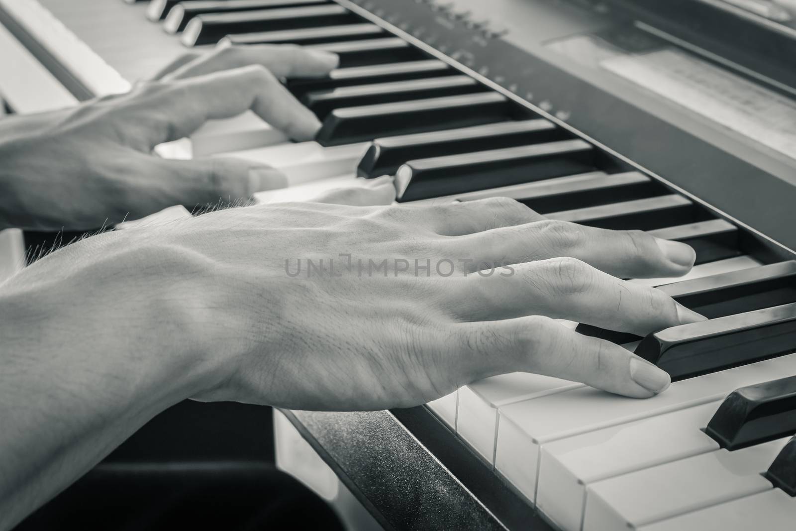Hand of Piano Player on White Keys and Black Keys of Electric Piano in Crosswise View