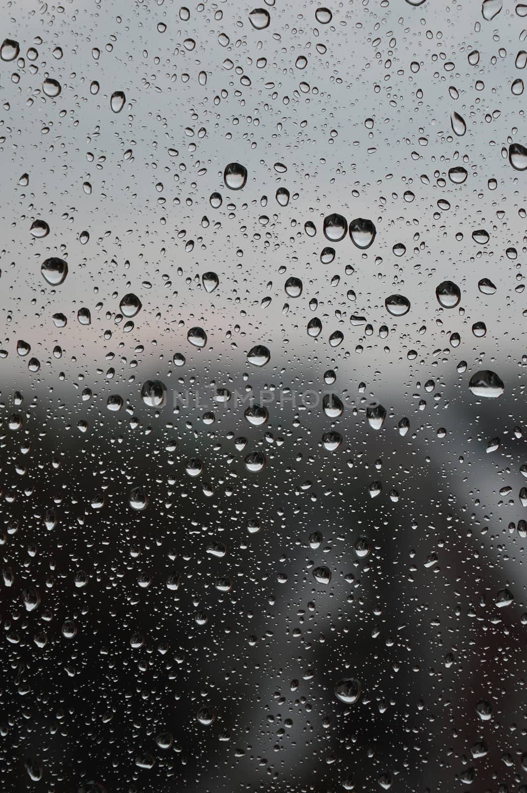 Drops of rain on the window, rainy day, dark tone. Shallow DOF