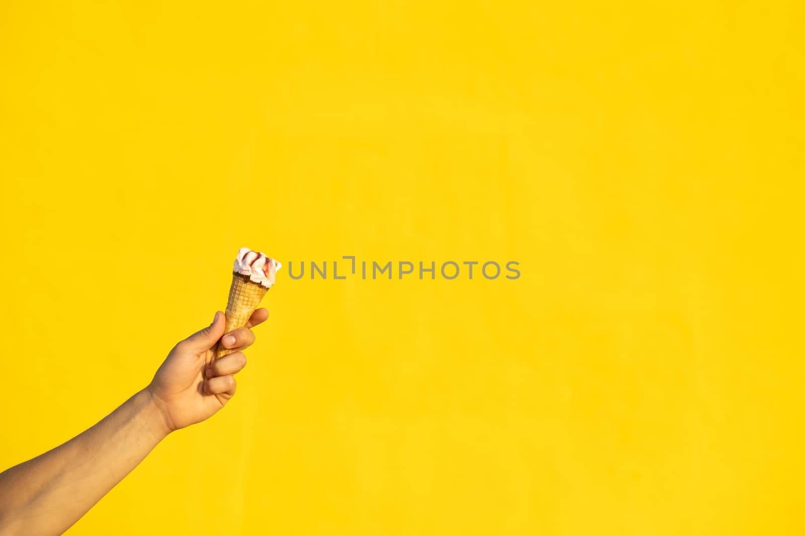 Ice cream with one hand on a yellow background