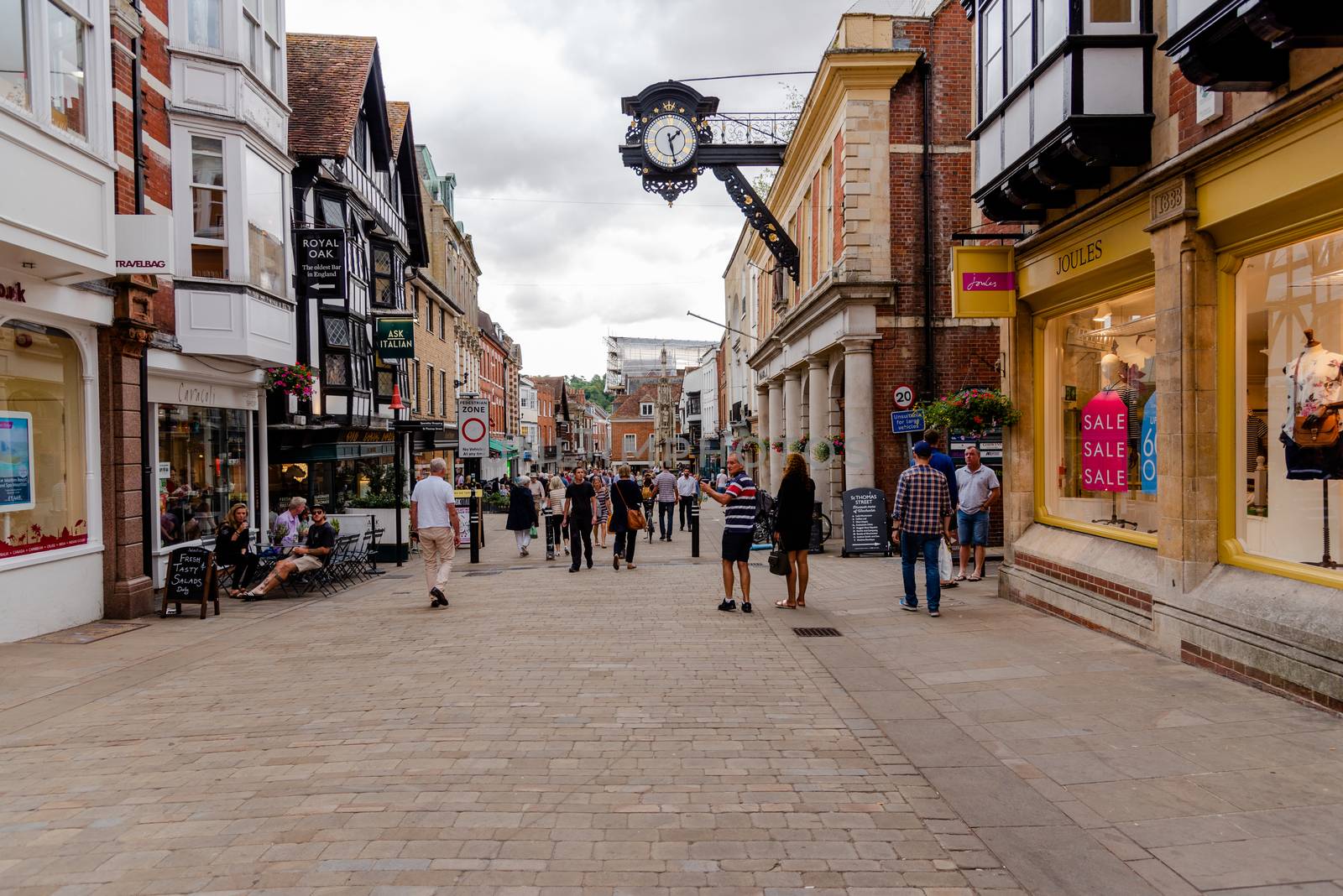 Winchester, United Kingdom--July 17, 2018. Wide angle shot of shoppers on the high street in Winchester, England on a summer afternoon.