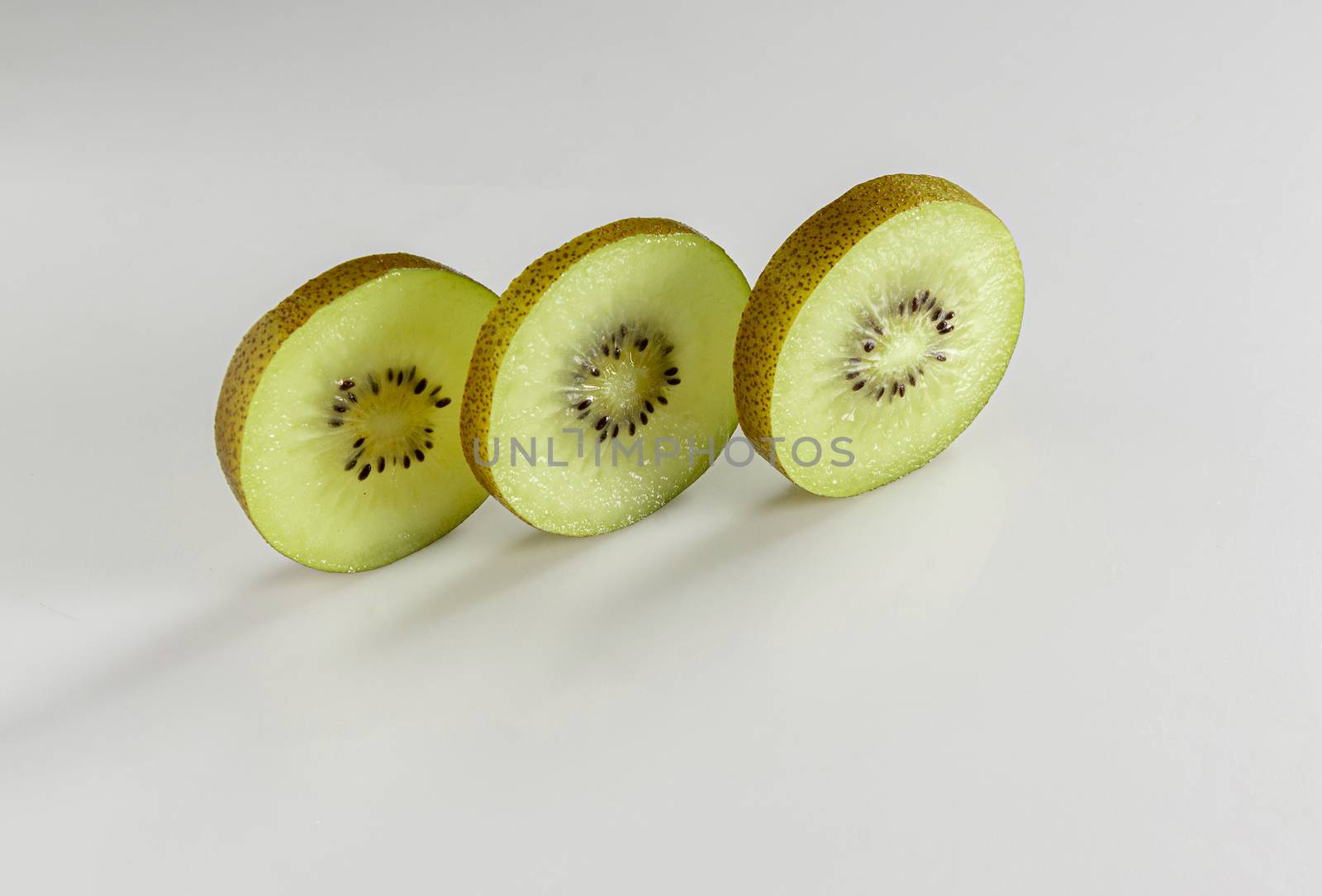Kiwi sliced in three layers stand against a white background by ben44