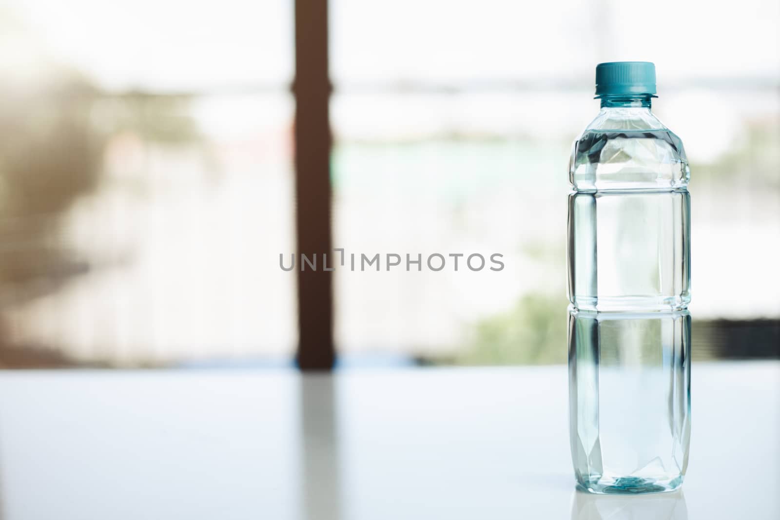 Water bottle on the table against blurred background for drinking and beverages concept