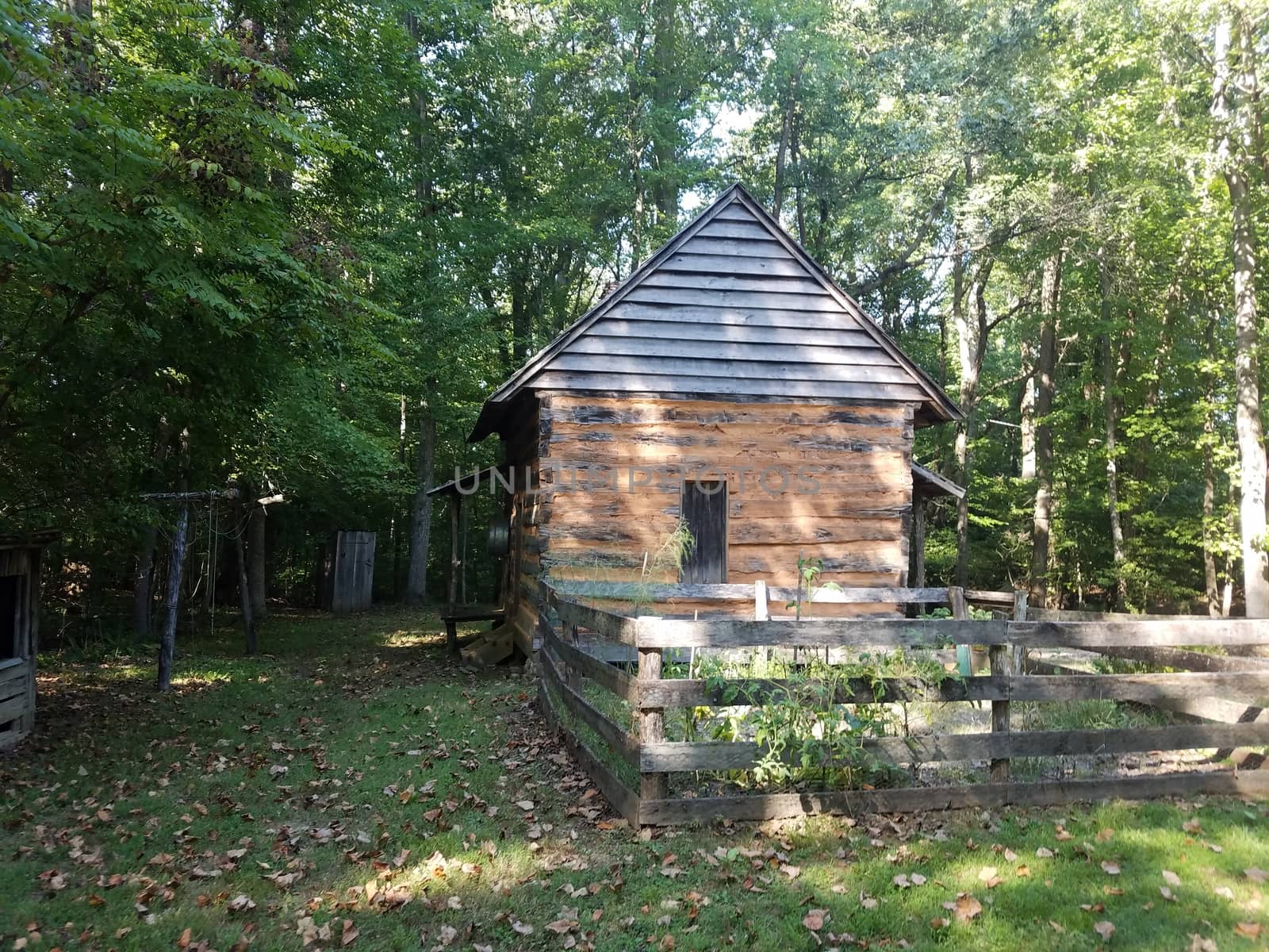 old log cabin with garden and wood shed and grass