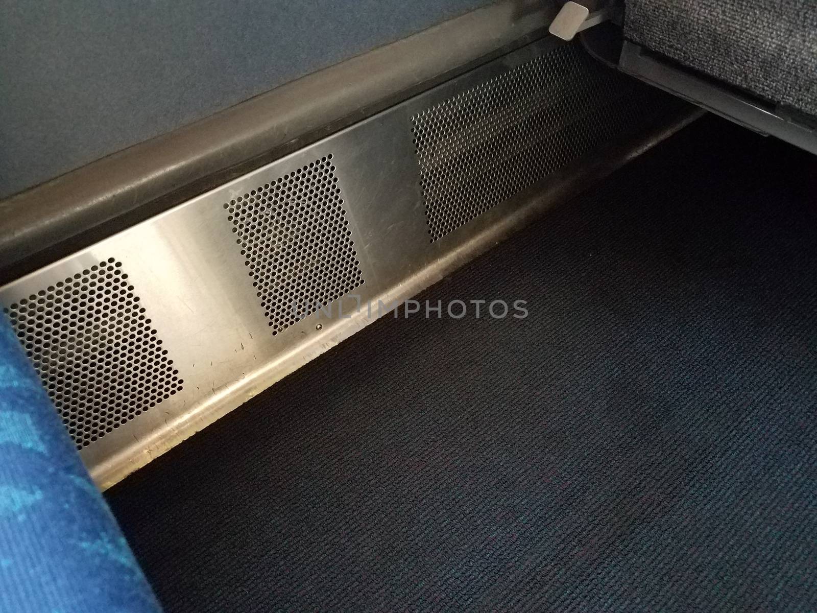 metal heater vent with holes in train with carpet