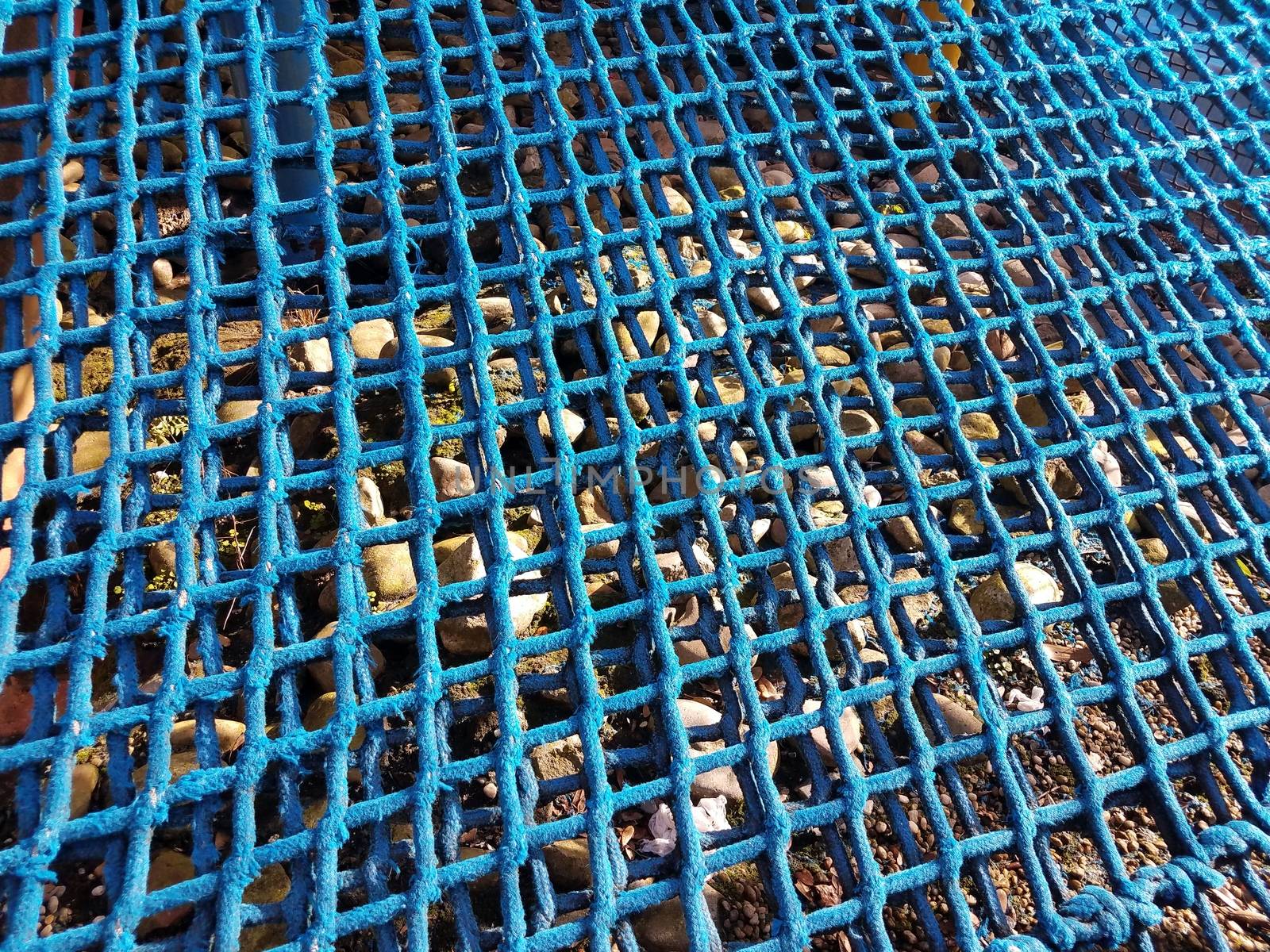 blue netting or net or rope with rocks or stones