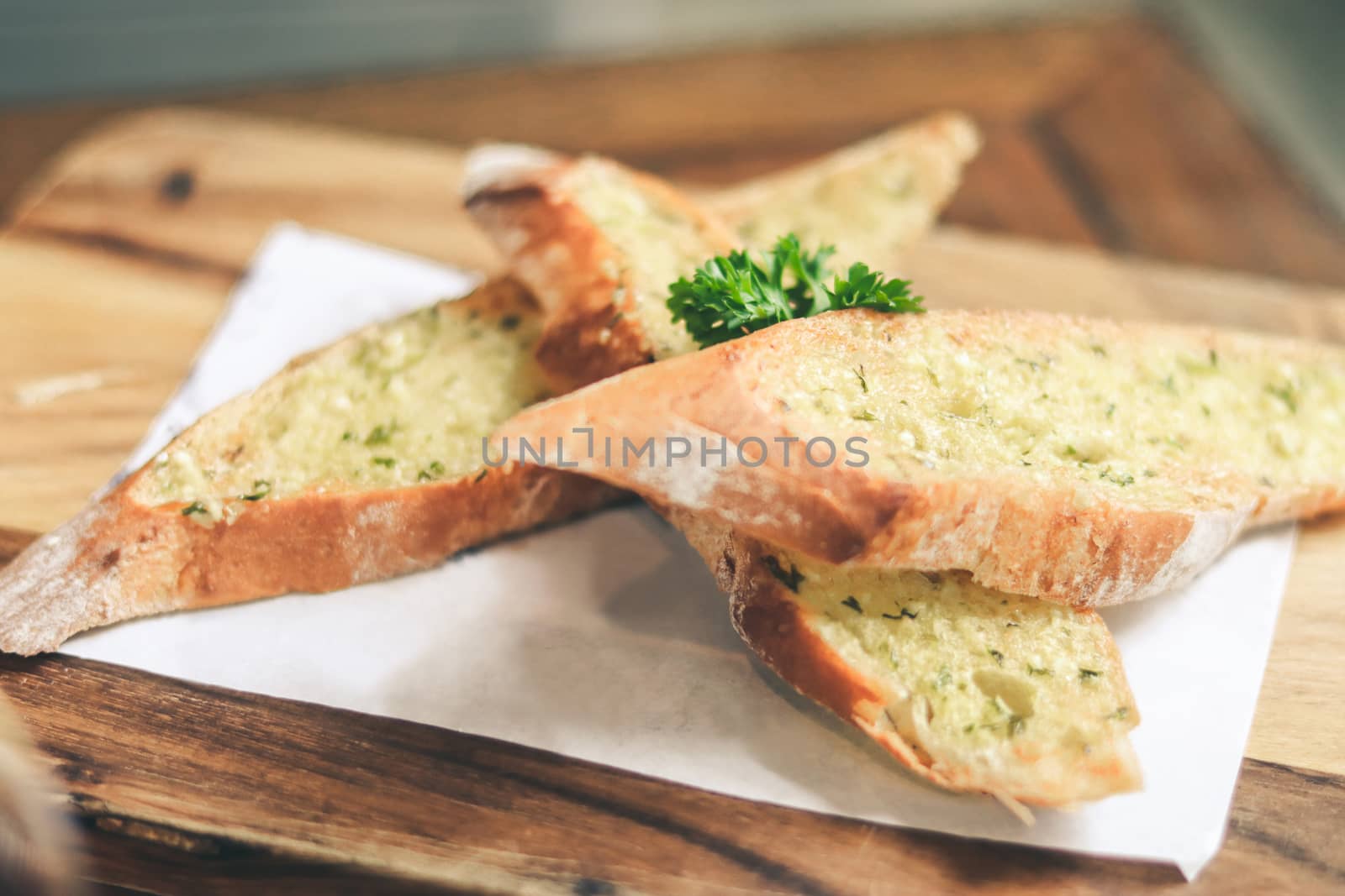 Close up Freshly baked garlic bread on wood plate. by anotestocker