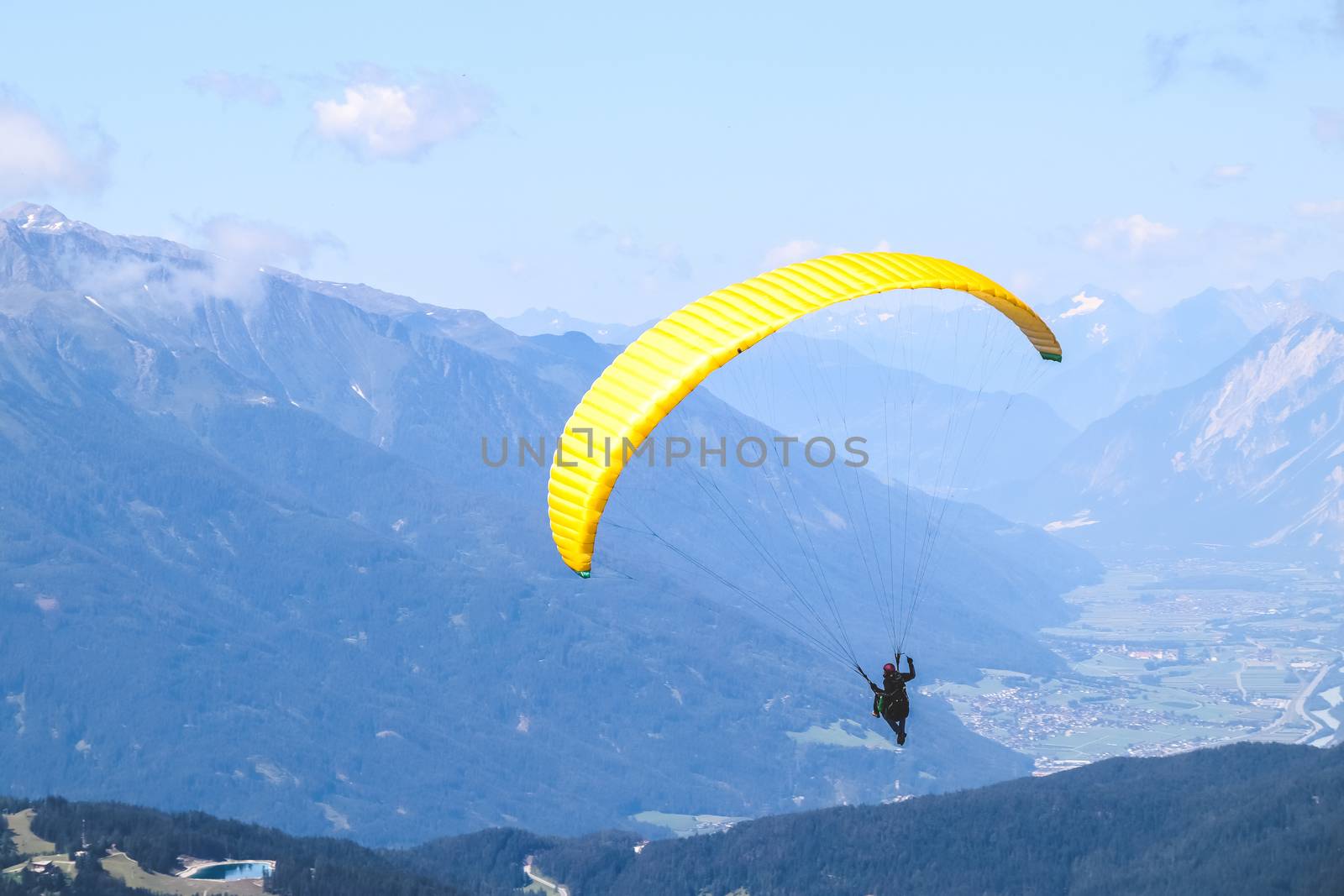 Paraglider soaring in the blue sky over the beautiful mountains.