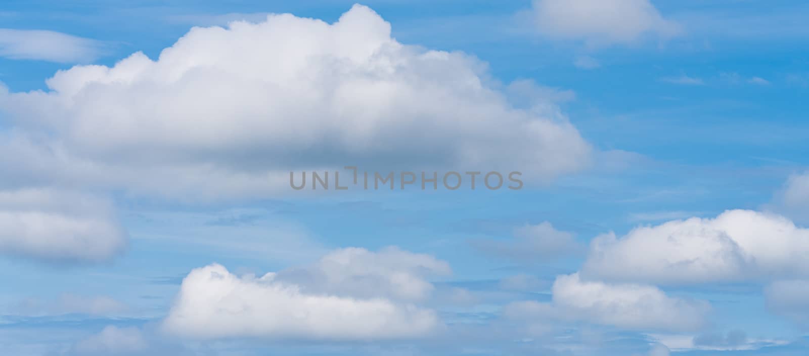 Beautiful colorful panorama of sunny summer blue sky with white clouds. Panoramic view of natural meteorology background landscape.