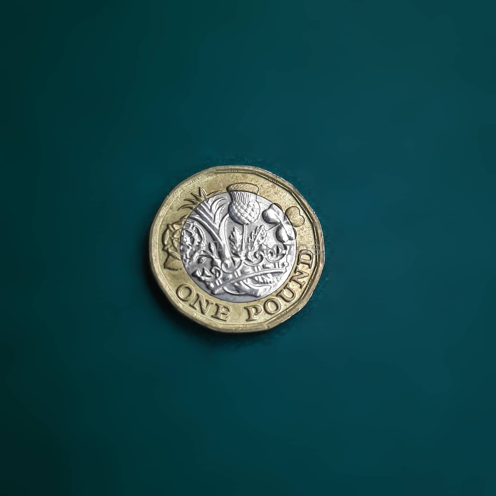 One pound coin is placed in green chart background