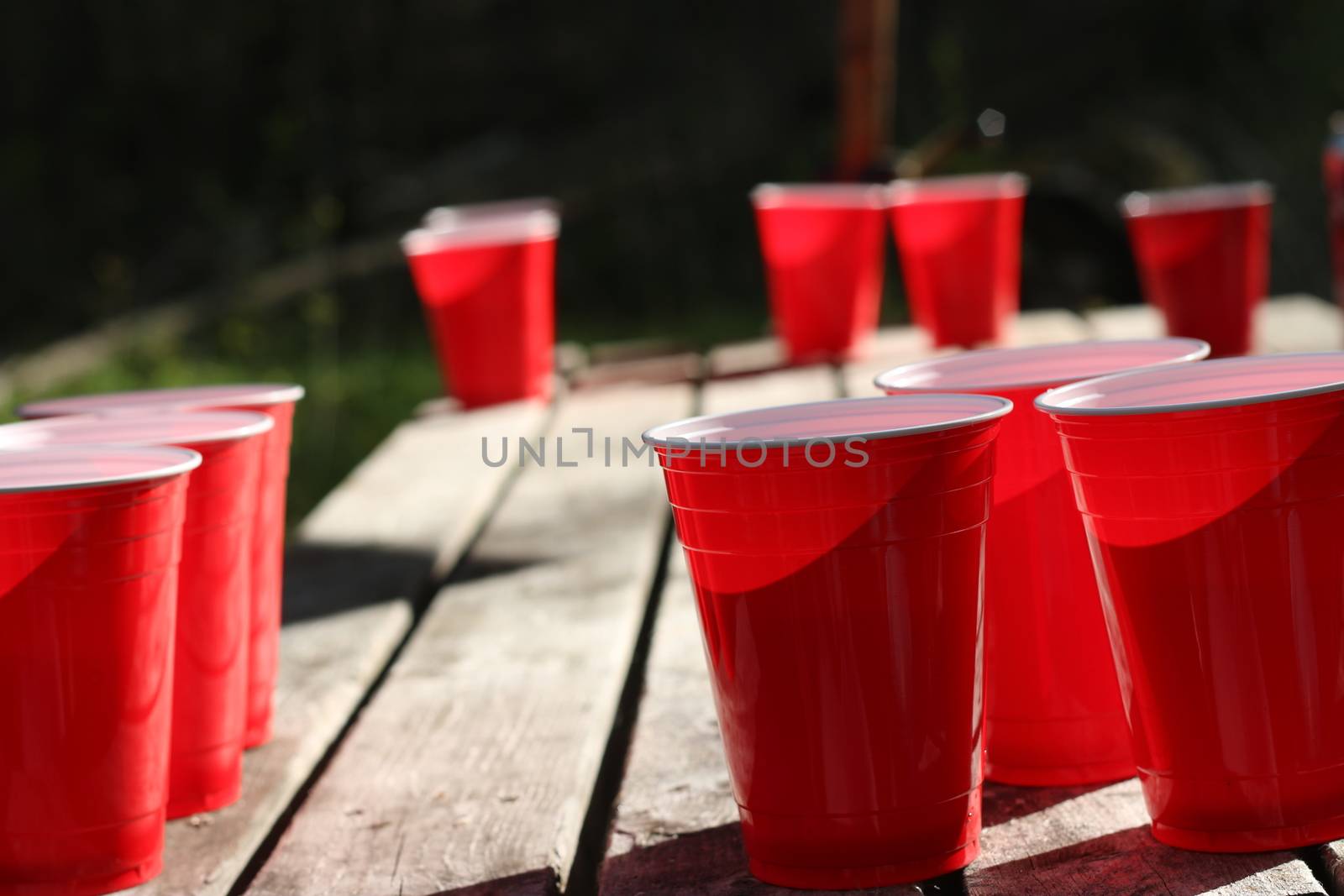 Red party cups themed background template. White backdrop. Alcohol container on its side. People dancing hands up in the air. Empty blank copy space. Event marketing and promotion