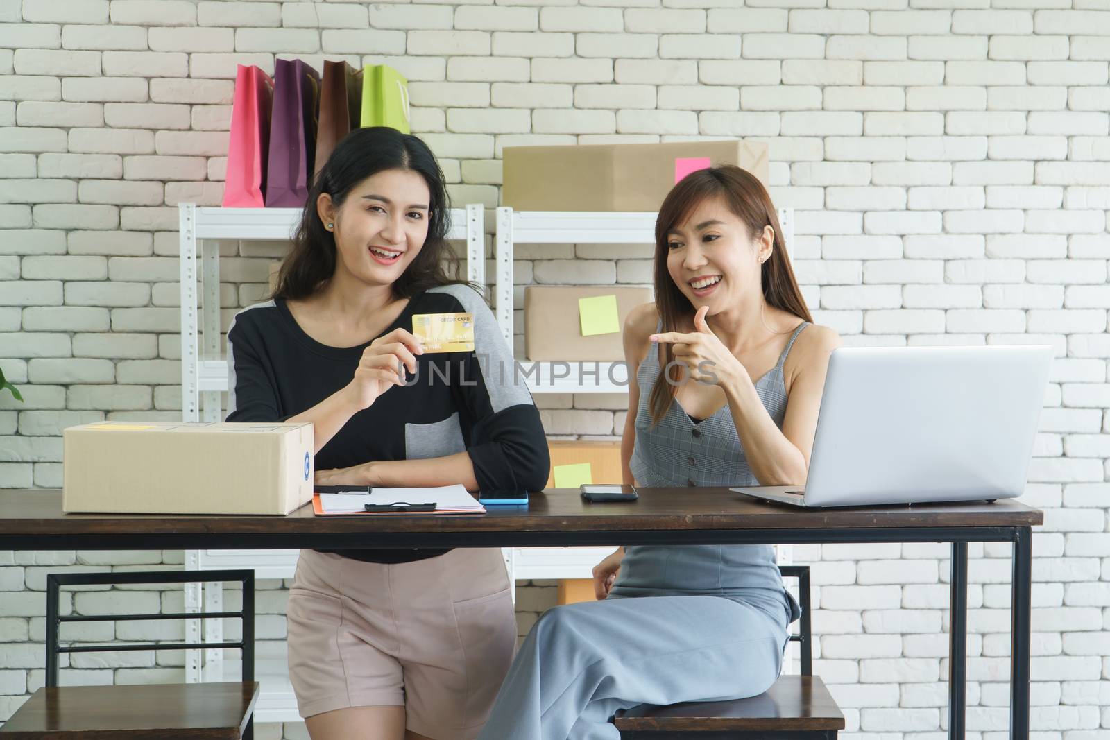 Entrepreneurs the online sales business, attractive Asian women holding a credit card, are checking orders from customers from the computer. Merchant business owner Small  marketing using technology