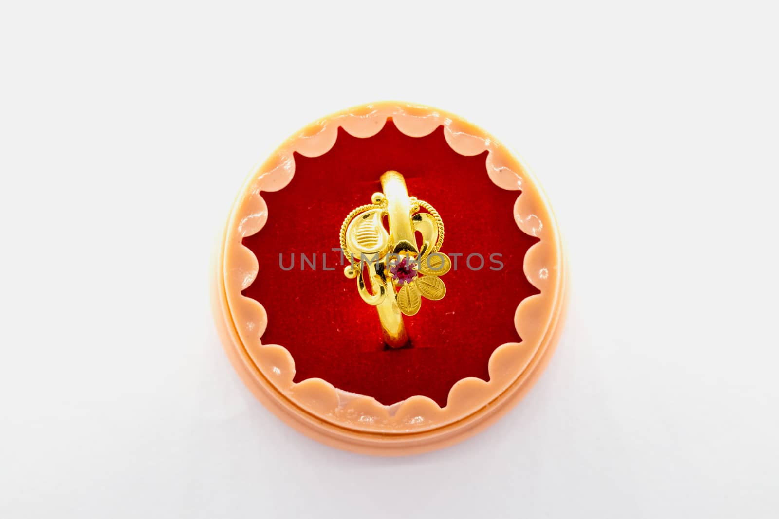 one red stone gold ring in the box with white background