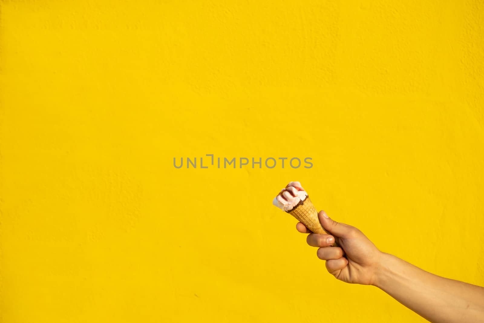 Ice cream with one hand on a yellow background