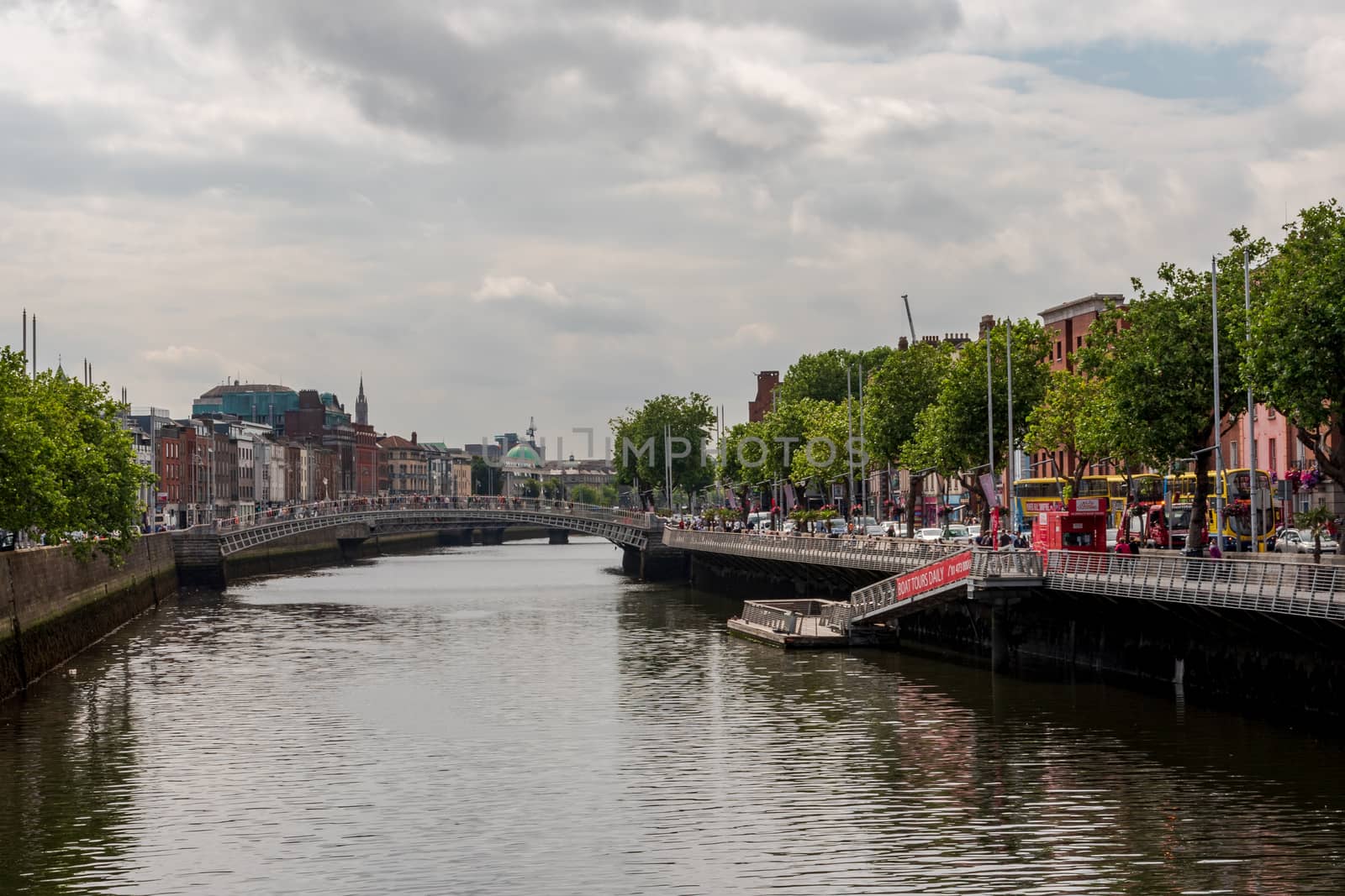 Dublin, Ireland -- July 9, 2018.  The sidewalks and streets on the banks of the River Liffey in Dublin, Ireland are crowded with travelers and tourists.