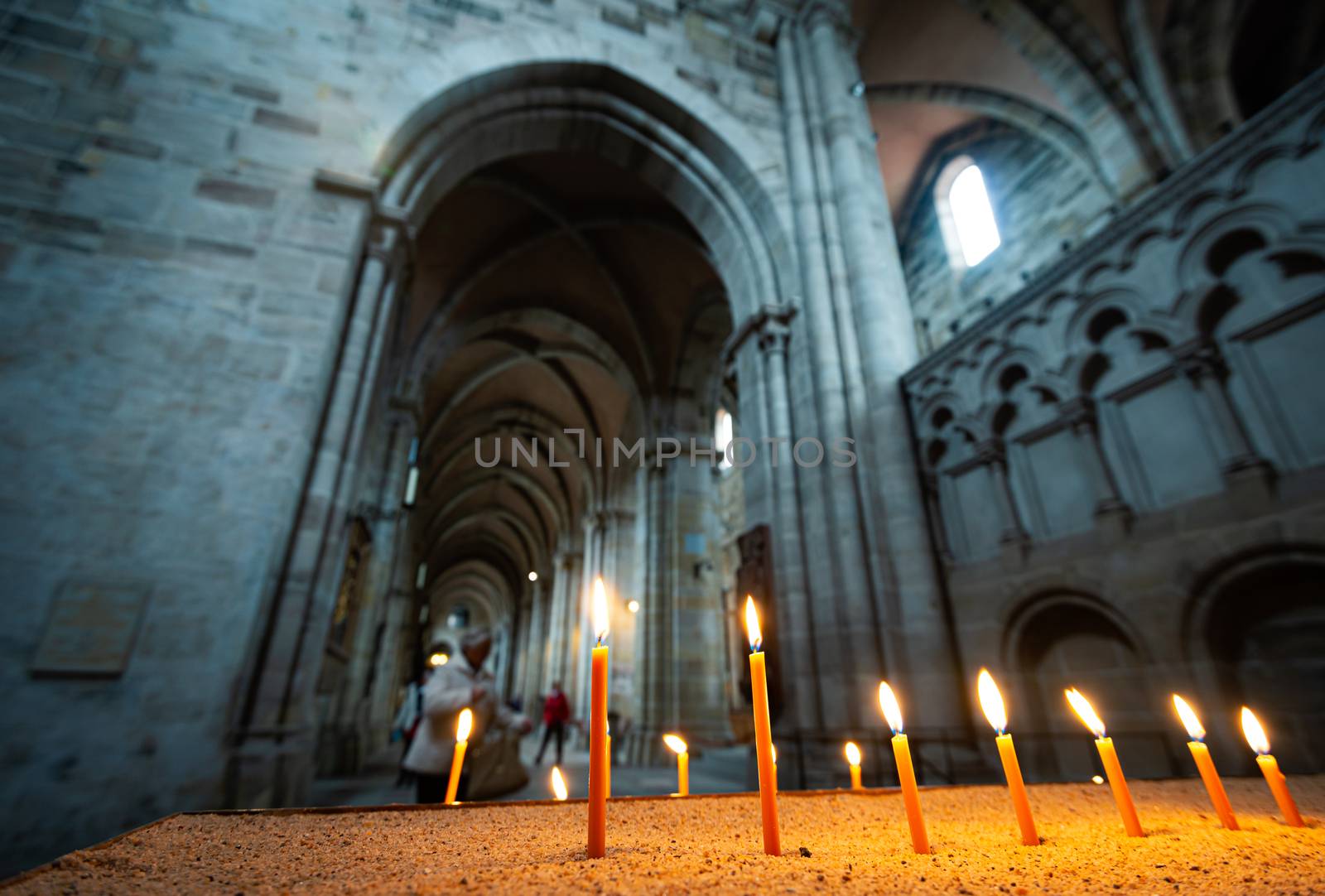 Architecture of beautiful old church in Germany. Candles in foreground and arches in background