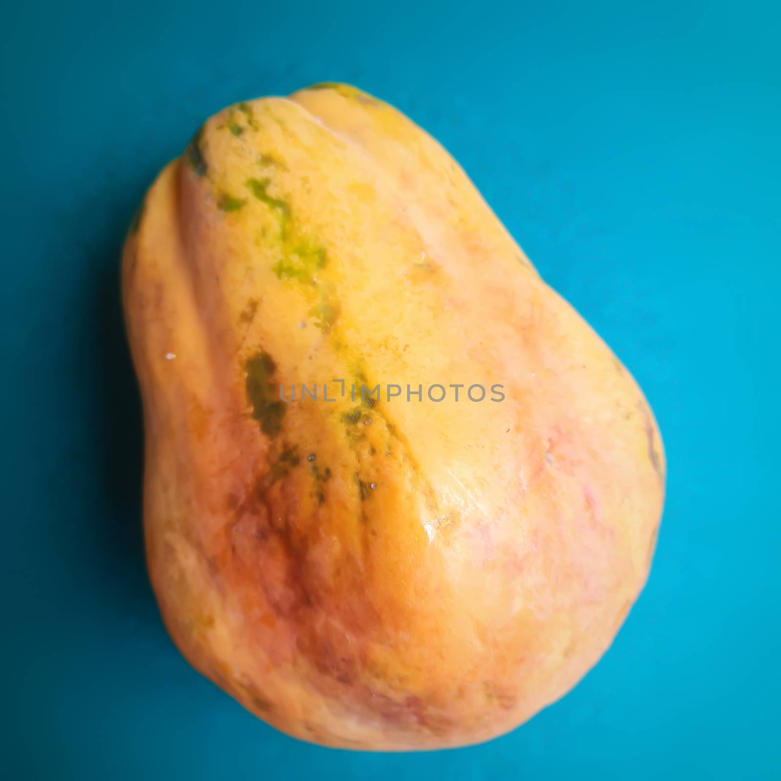 Yellow color fresh papaya kept in blue color background and rich in fibre Vitamin C and antioxidants Boosts your immunity Good for diabetics and eyes also prevent cholesterol build up in our arteries