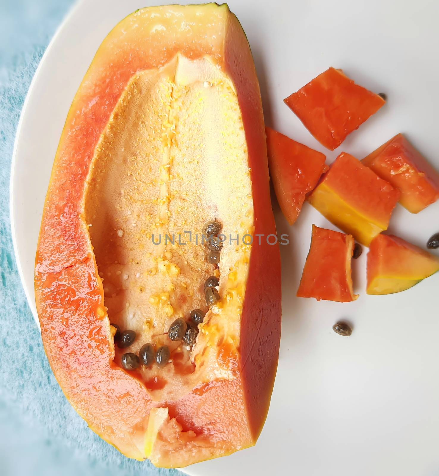 Orange color fresh papaya kept in white background with cut pieces and rich in fibre Vitamin C and antioxidants Boosts your immunity Good for diabetics and eyes