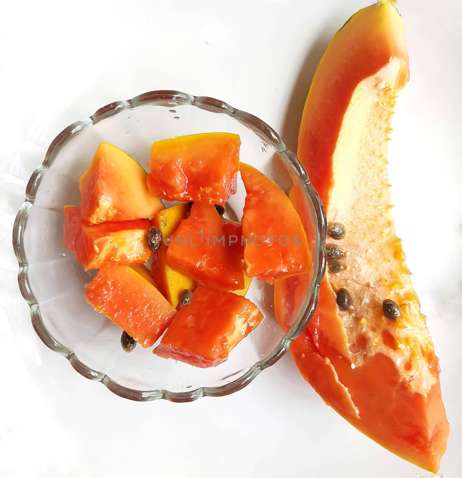 Orange color fresh papaya kept in white background with cut pieces in bowl and rich in fibre Vitamin C and antioxidants Boosts your immunity Good for diabetics and eyes