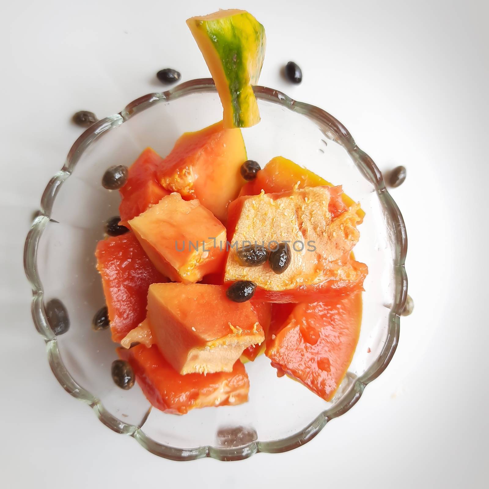 Orange color fresh papaya kept in white background with cut pieces in bowl and rich in fibre Vitamin C and antioxidants Boosts your immunity Good for diabetics and eyes