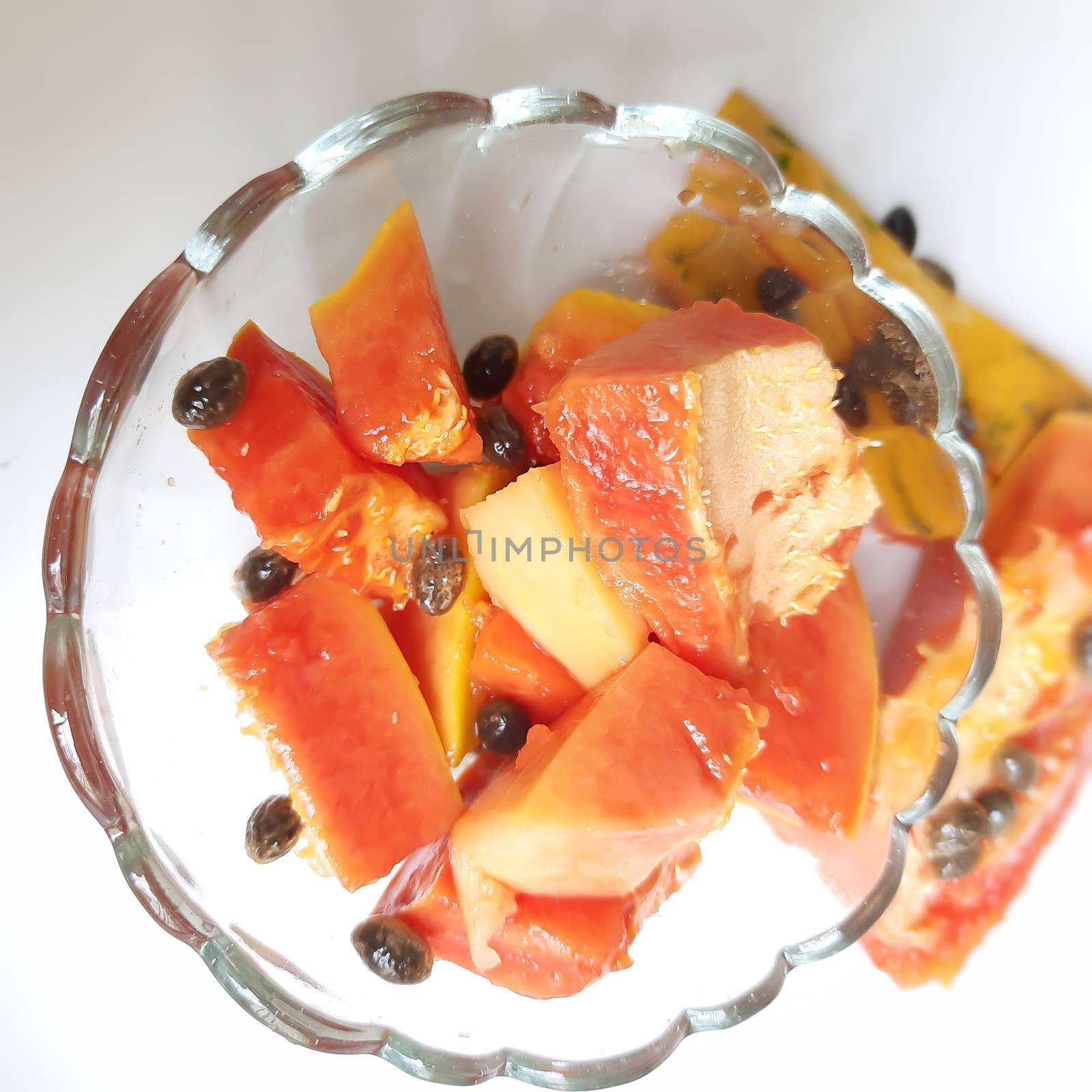 Orange color fresh papaya kept in white background with cut pieces in bowl and rich in fibre Vitamin C and antioxidants Boosts your immunity Good for diabetics and eyes