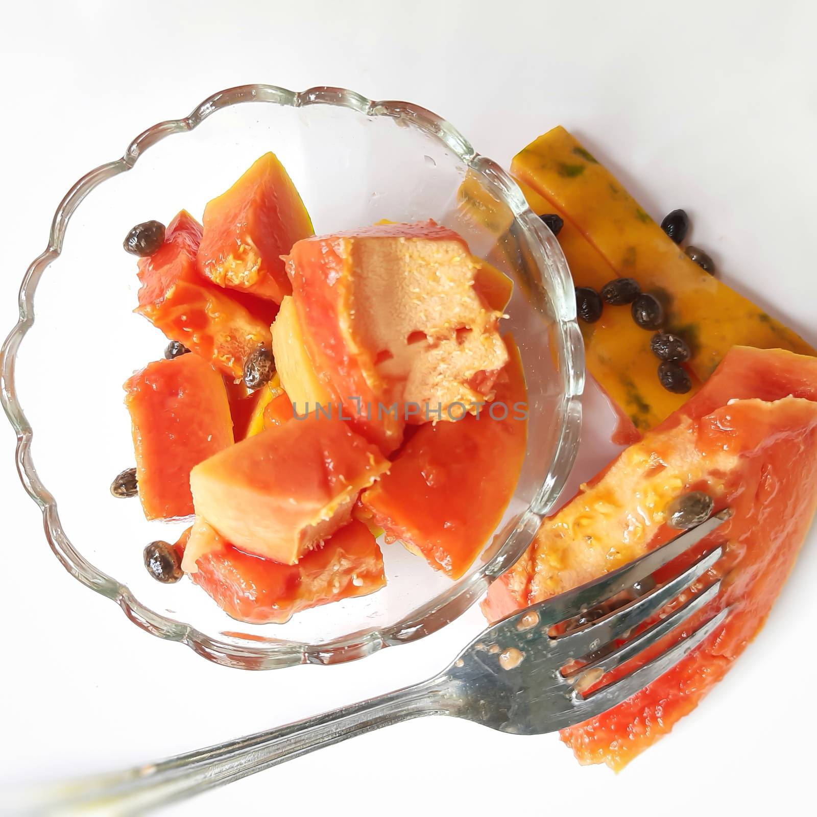 Orange color fresh papaya kept in white background with cut pieces in bowl and rich in fibre Vitamin C and antioxidants Boosts your immunity Good for diabetics and eyes