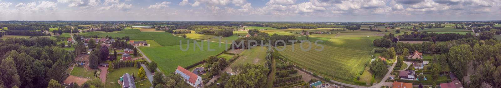 Aerial panorama view on a countryside area in Belgium with houses and agricultural fields by kb79