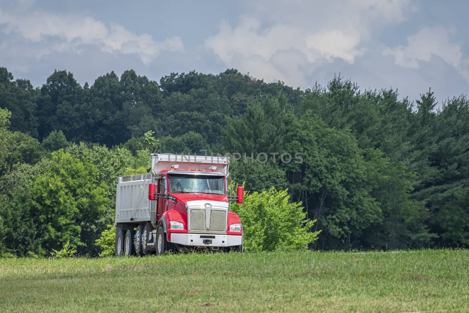 Heavy-Duty Dump Truck Enters Highway From Access Ramp in Summer by stockbuster1